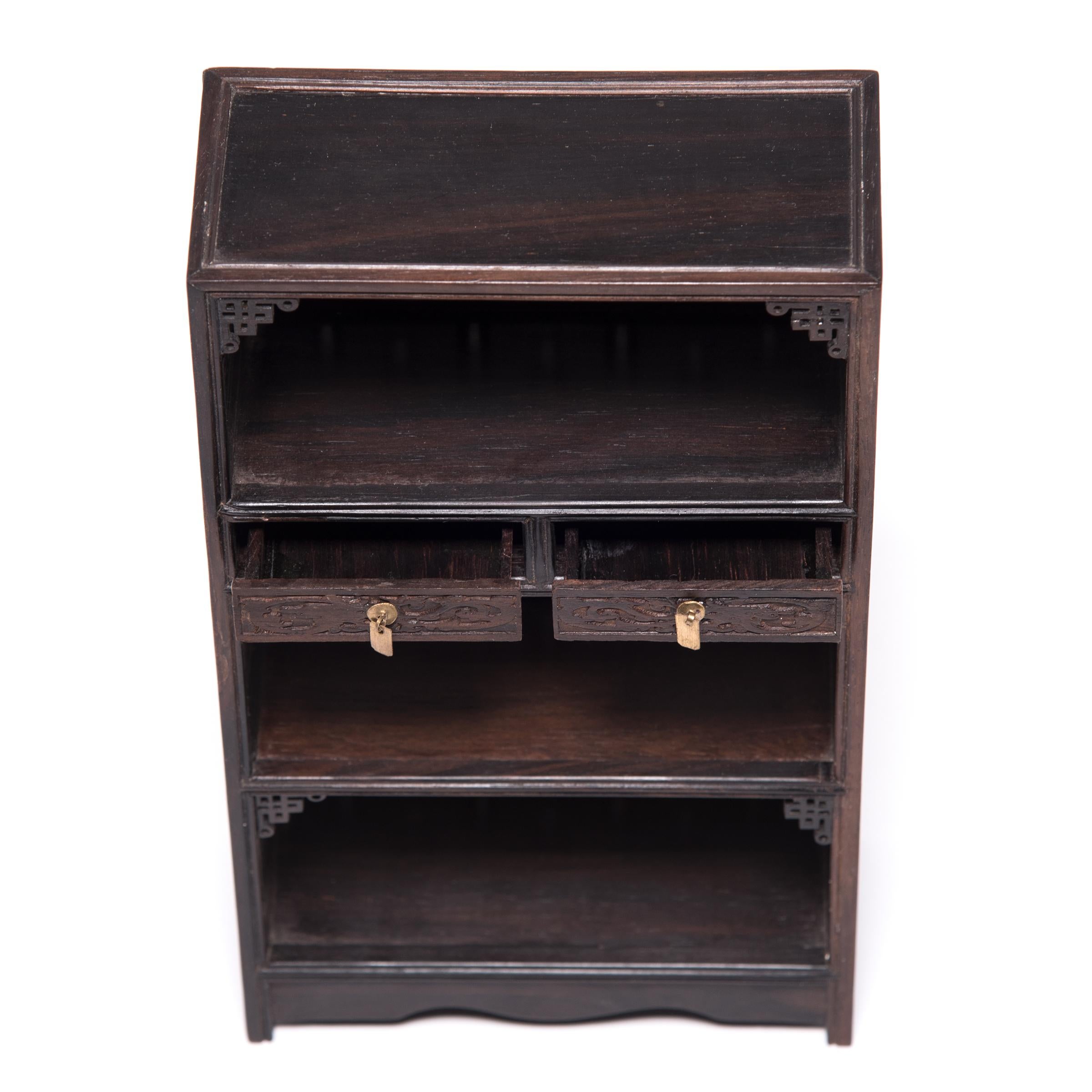 A full size bookcase with this level of workmanship and detail would be an incredible find, but this beautiful piece of furniture—at only nine inches tall—is perfectly constructed down to the tiniest minutia. The bookcase was made in northern China