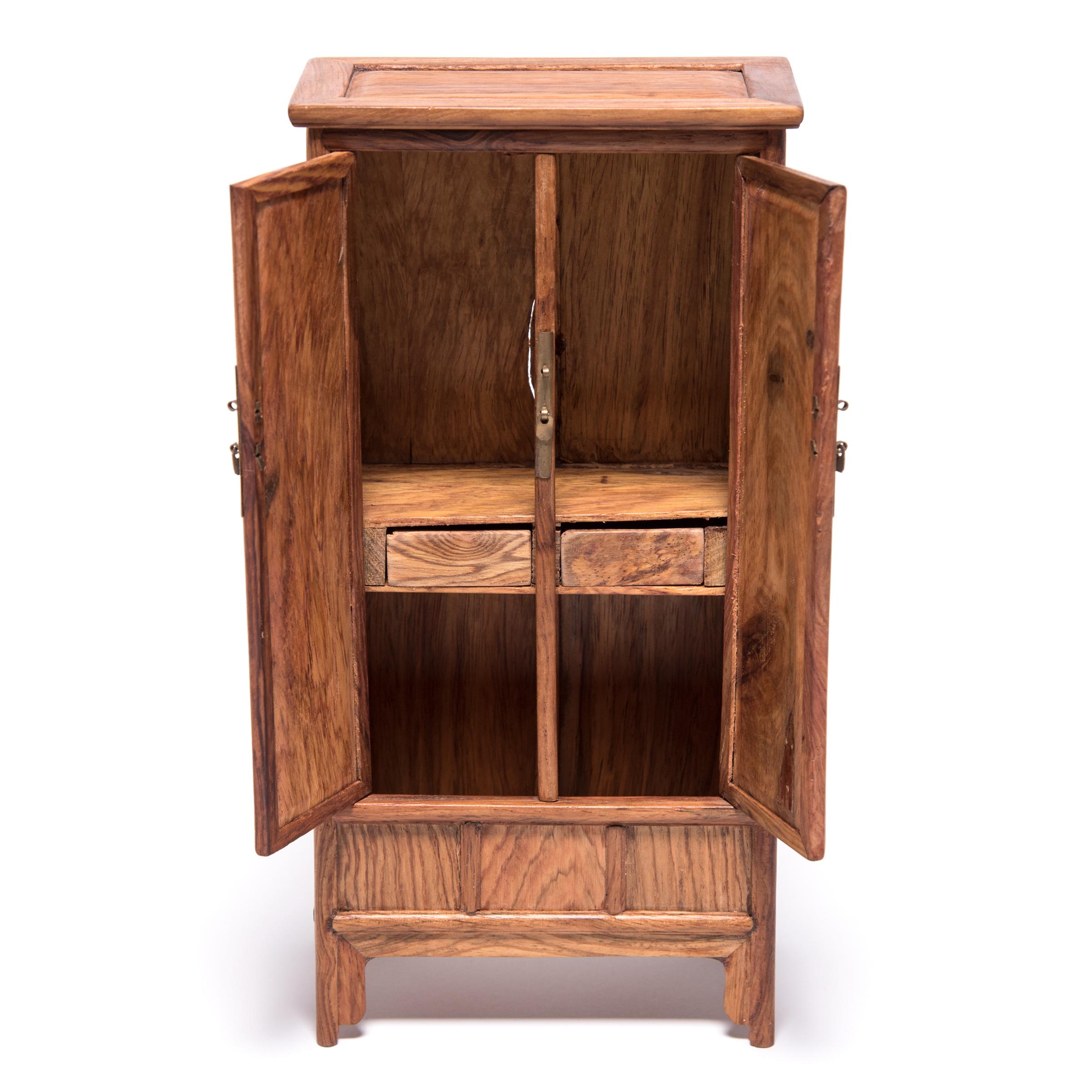 A full size cabinet with this level of workmanship would be an incredible find, but this beautiful piece of furniture—at only nine inches tall—is perfectly constructed down to the tiniest minutia. The cabinet was made in Northern China out of