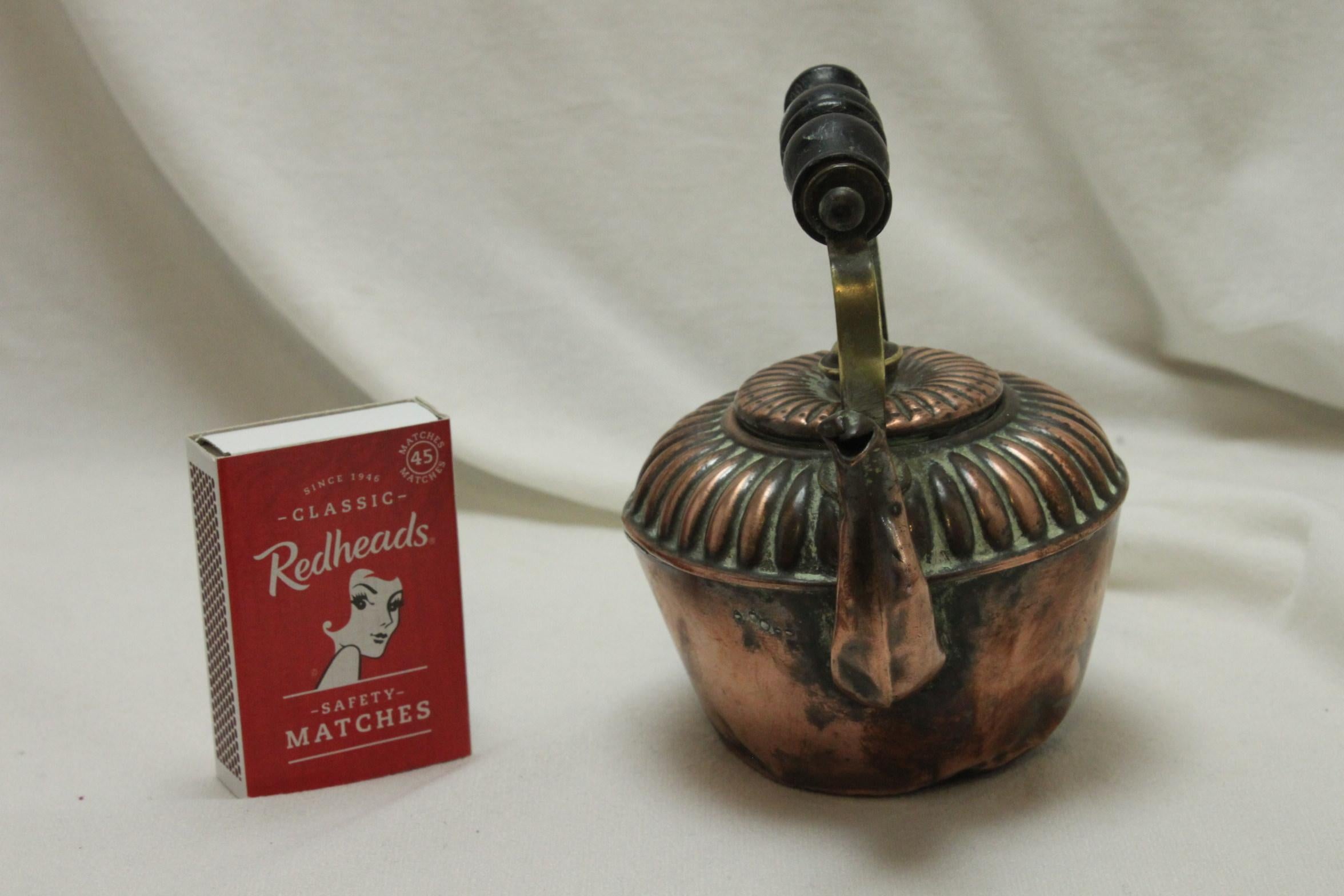 This miniature copper kettle was probably a salesman's sample, which would be far easier to carry around than a proper sized one. The body is copper, the knob for the lid is brass, as are the handle supports, which carry the turned and ebonised