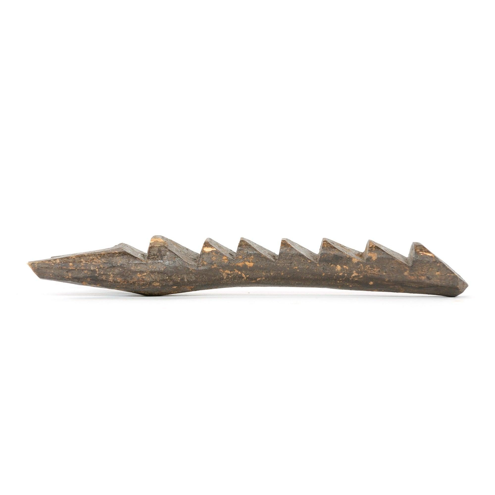 A miniature wooden Dogon ladder with seven steps and split top.