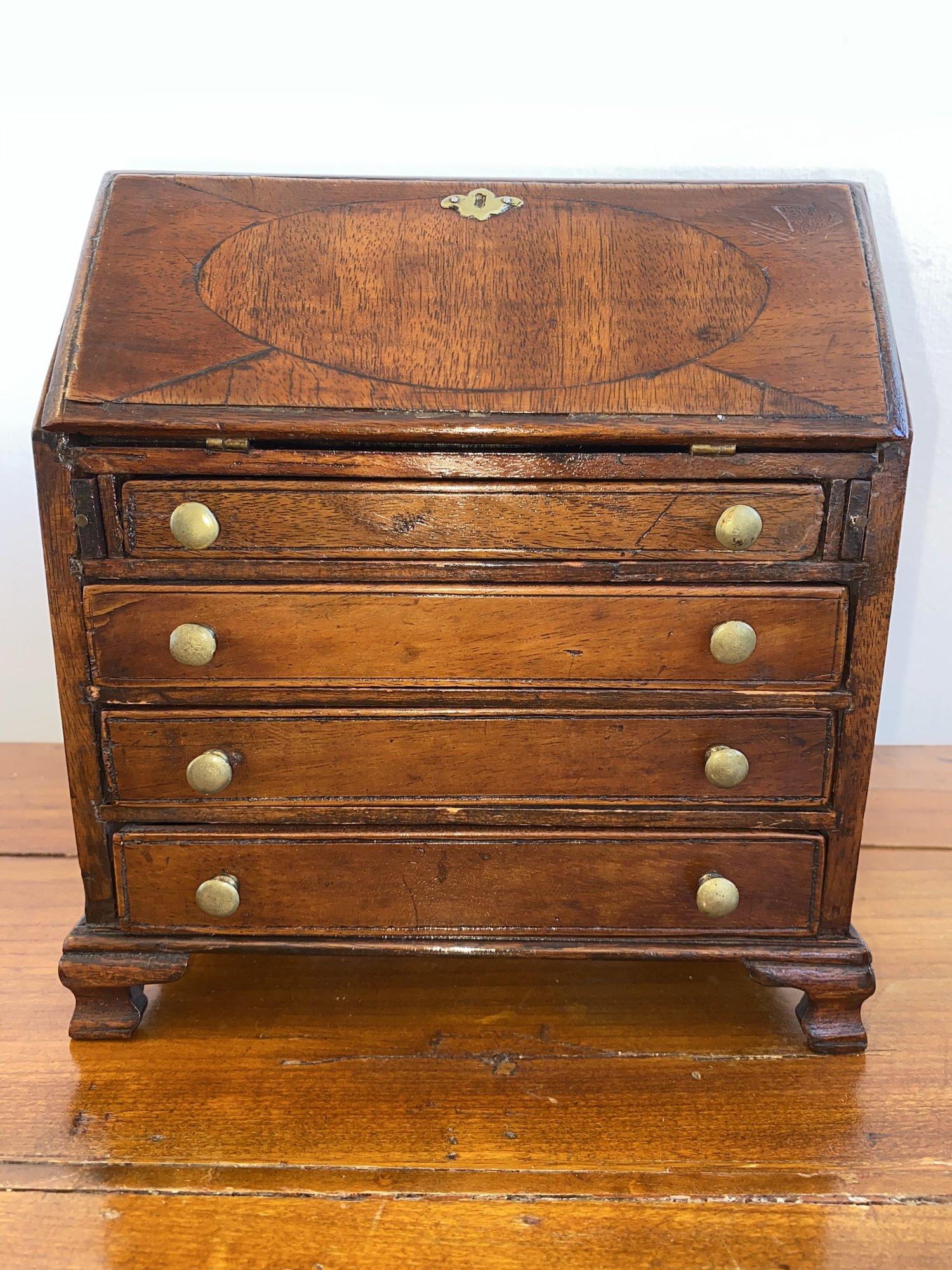 Miniature drop-front secretary, early 19th century, likely English, including a miniature brass candlestick and miniature salver.