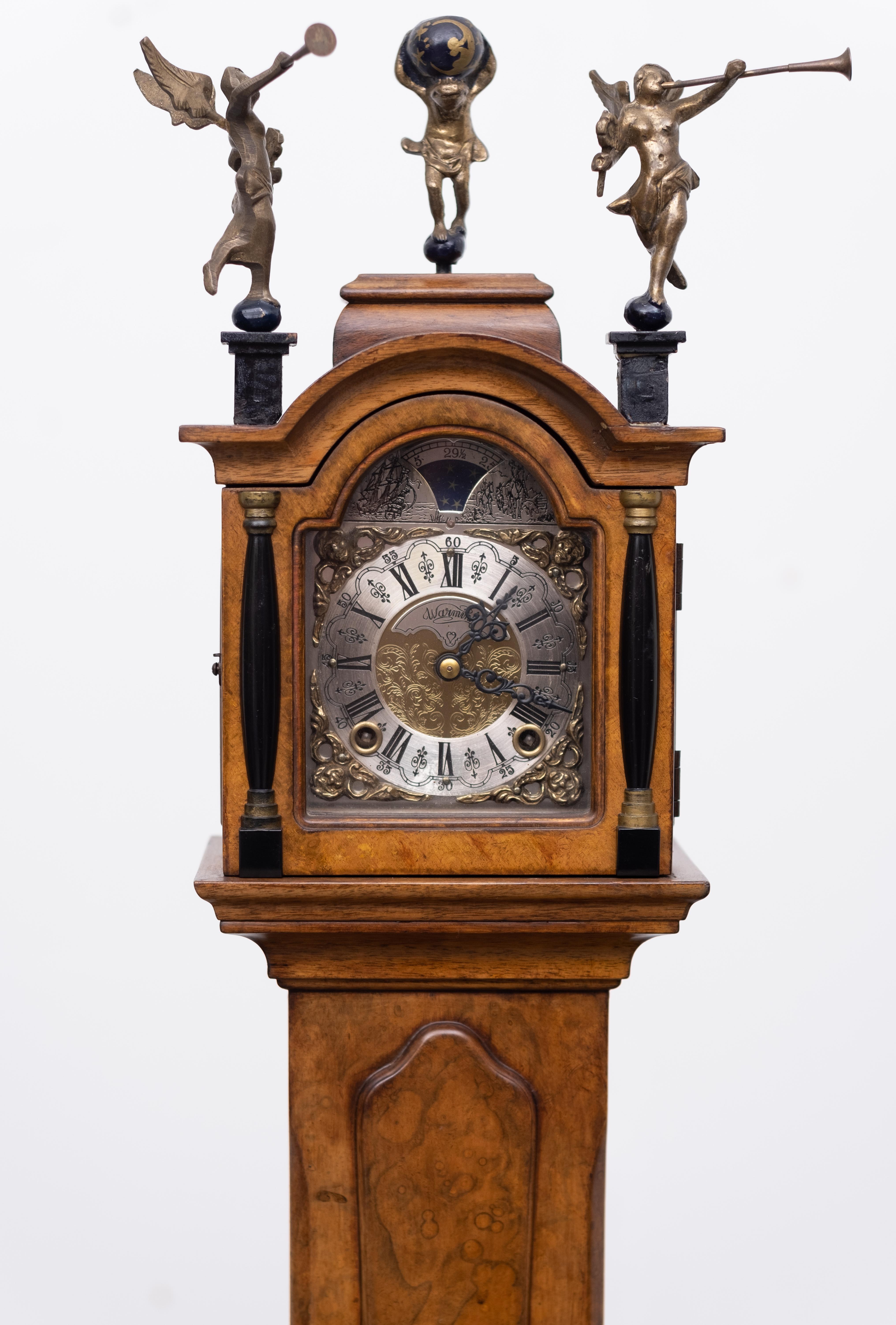 Love this miniature Dutch walnut long case clock. Not only great looking but also a good working
time piece. Comes with a good quality watch. Manufactured by Wuba 8 days winding.
topped with Atlas holding the world and two trumpeting angels