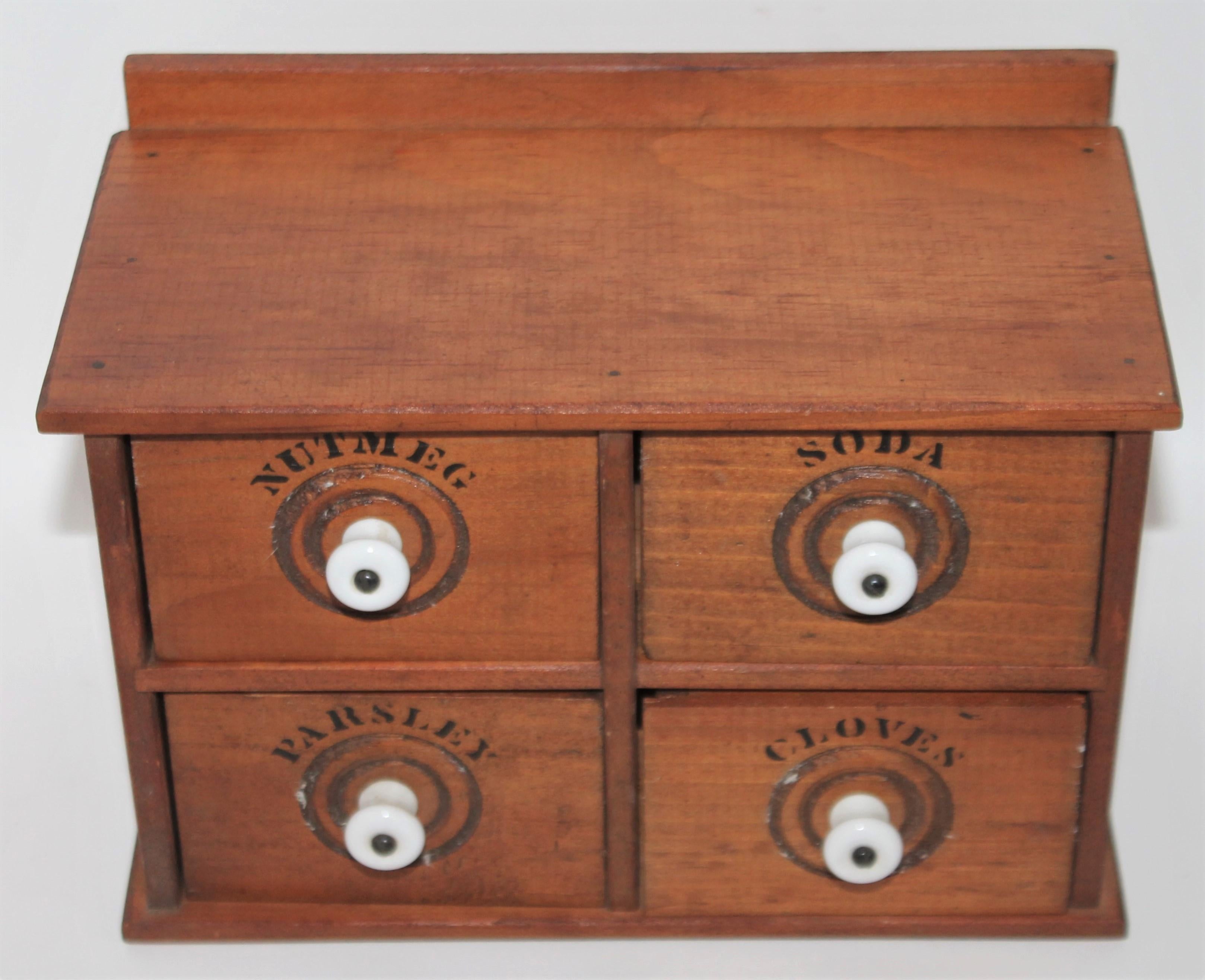 Miniature early 20th century spice box with original hardware and original porcelain drawer pulls. This small table top spice box has great bones.