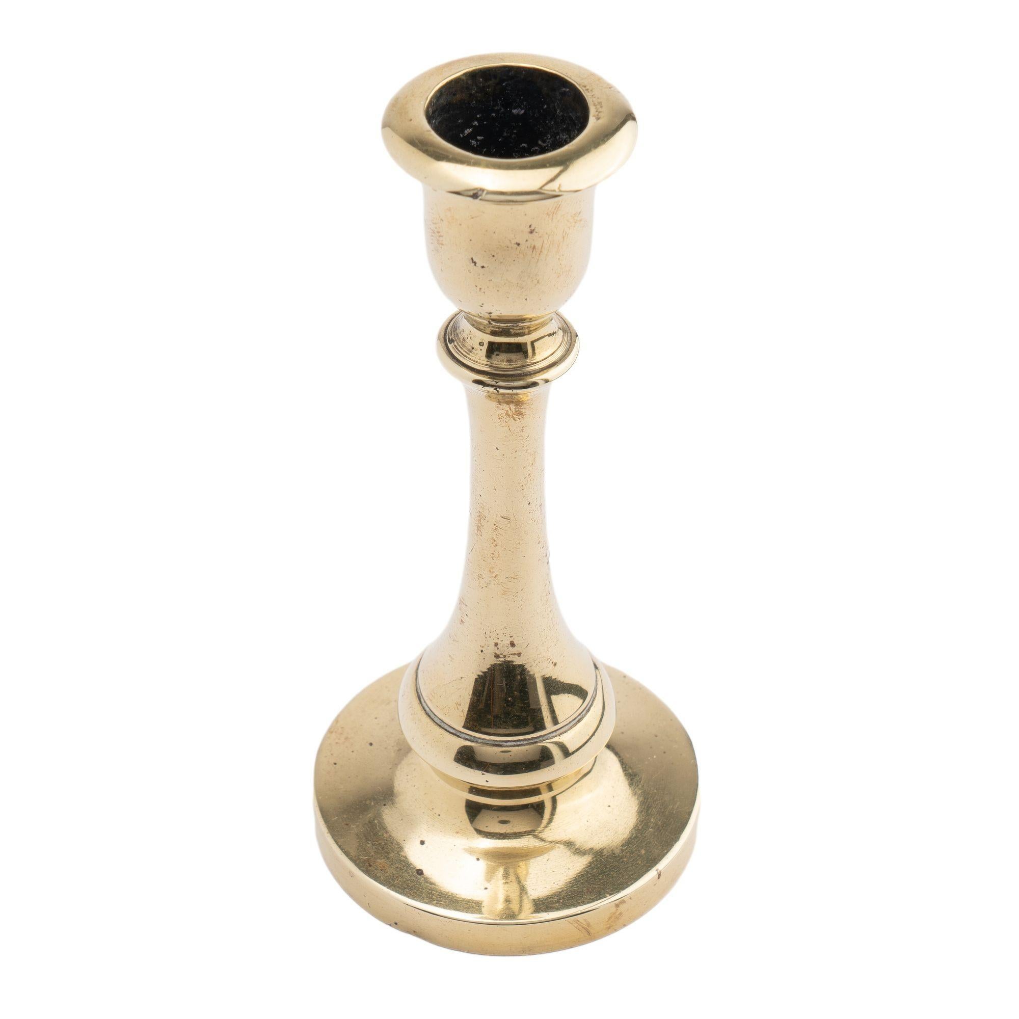 Late Georgian hollow core cast miniature brass candlestick. The candle cup with bobeshe is supported by an inverted trumpet candle shaft to a quarter round & waist to a circular base. Cast as a single piece.

England, circa 1800-20.