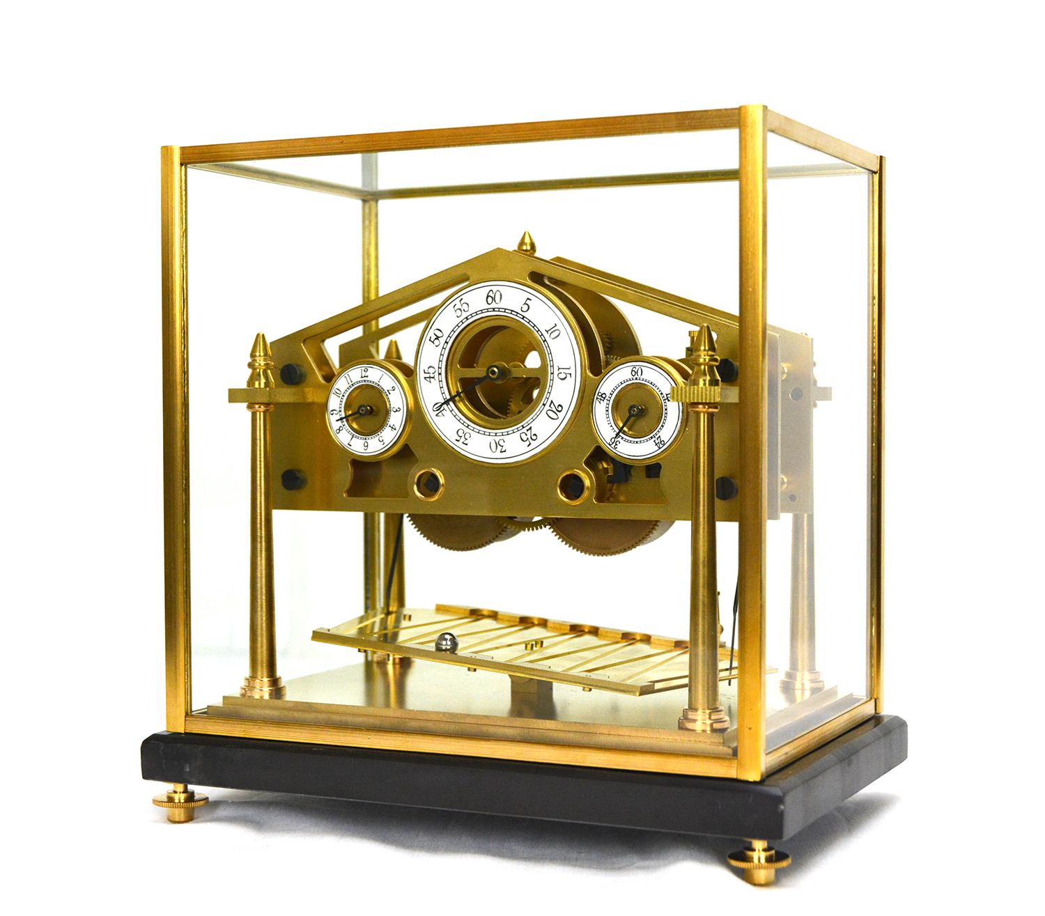 Here is a beautiful miniature Congreve rolling ball clock. This one comes with a solid marble display base and protective dome. The glass dome has solid brass frames. The clock is made of heavy solid brass. The time shows on 3 separated porcelain