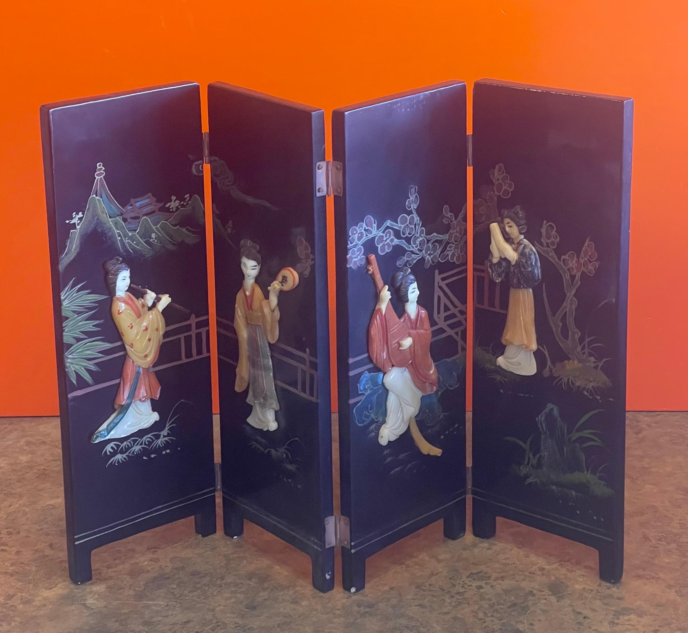 A very nice miniature four panel Asian figurine folding screen with intricate design in wood, circa 1970s. The screen is in good vintage condition and measures 14