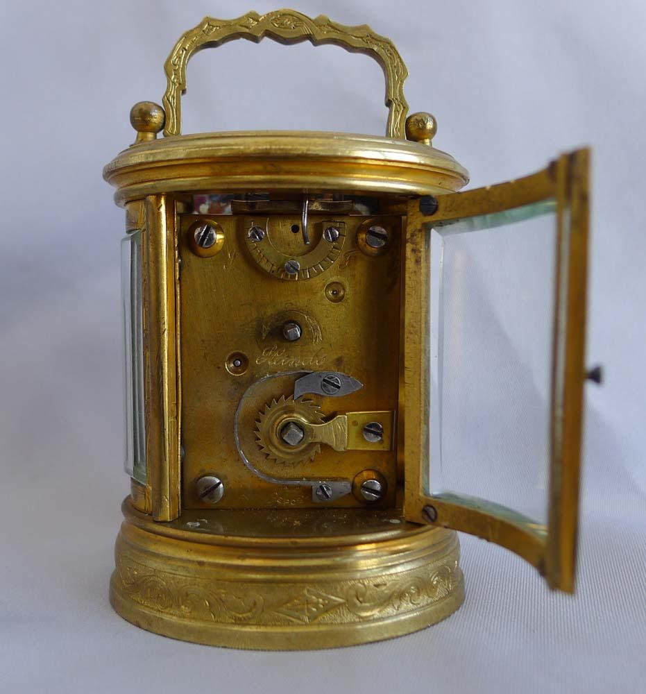 Carriage clock, oval, engraved, miniature and French. However this one was made for the English market as it is engraved on the backplate below the escapement, F and S for fast and slow rather than A and R for advance and retard as it would be for