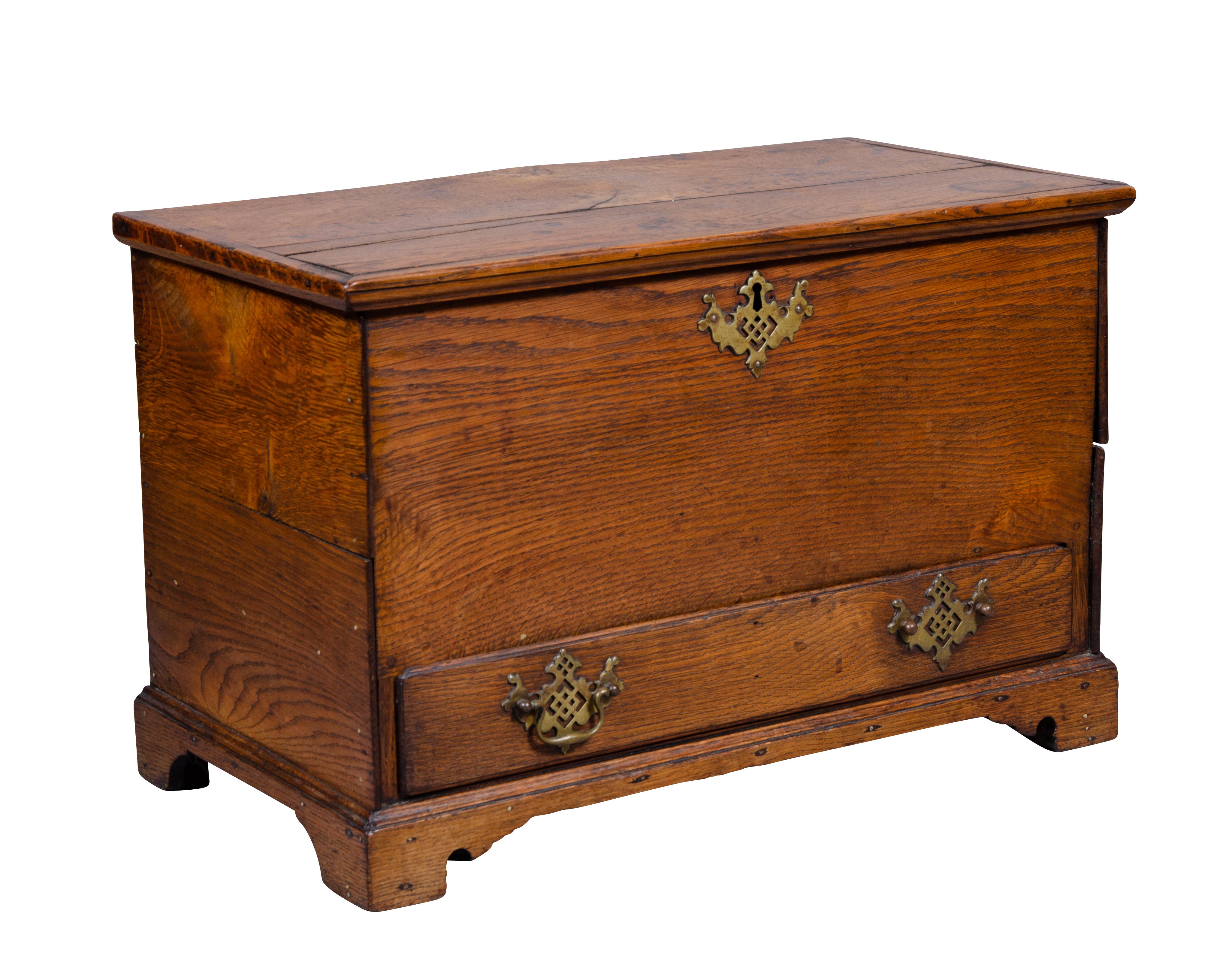 Simple piece with hinged lid opening to a storage compartment over a drawer, bracket feet.