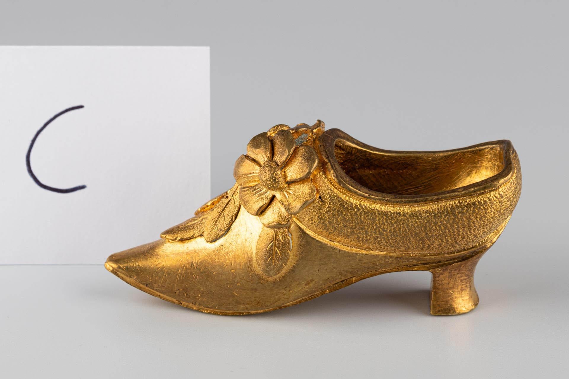 Miniature Shoe with Floral Ornament

Origin: France or Belgium
Material: Gilt bronze
Date: Late 19th century (c. 1880–1900)

Dimensions:
H × W × D: approx. 4.2 × 8.5 × 3.5 cm

Description:
Finely cast miniature shoe made of gilt bronze, inspired by