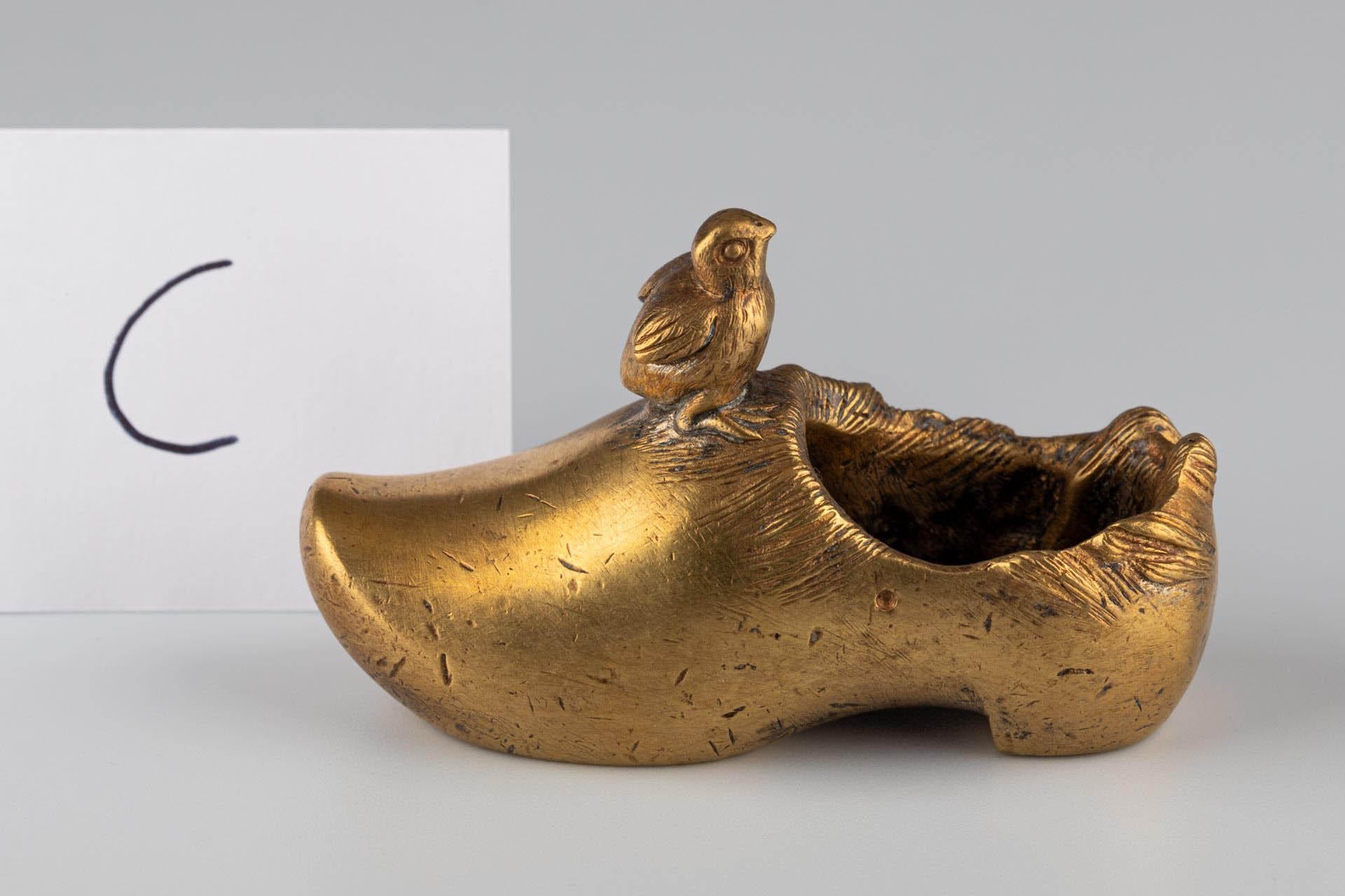 Miniature Shoe with little Bird

Origin: Probably France or Belgium
Material: Gilt bronze
Date: Late 19th century (c. 1880–1900)

Dimensions:
H × W × D: 5 × 8 x 3 cm

Description:
Solid cast miniature shoe in the shape of a traditional Dutch wooden