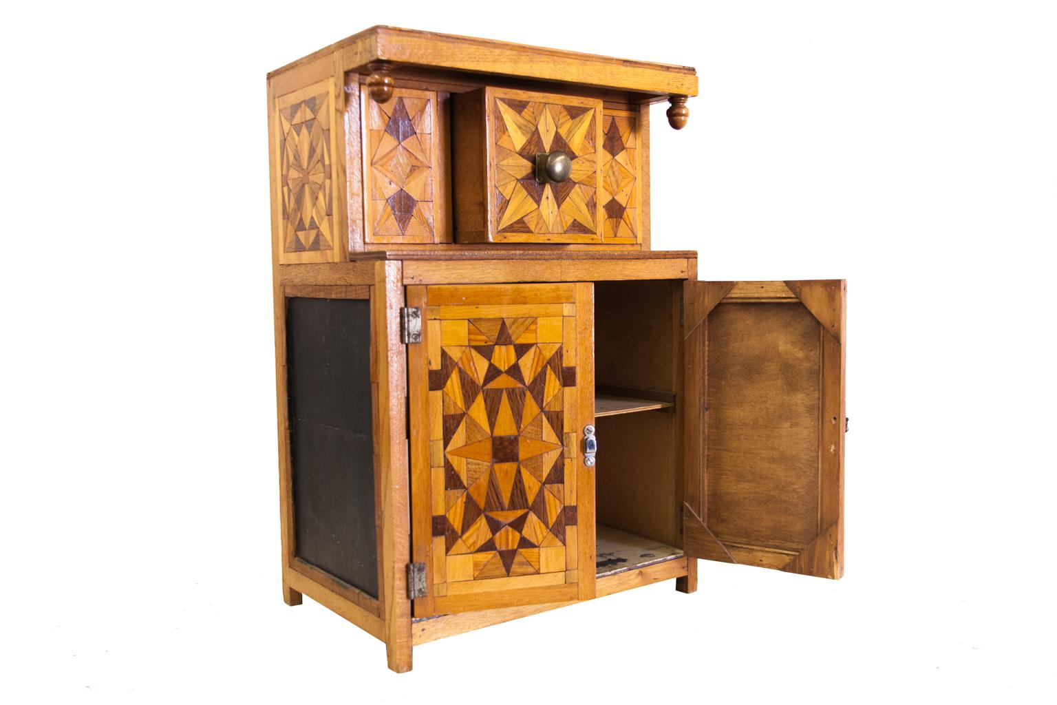 Miniature inlaid Tudor style court cupboard, with geometric inlaid mosaic on the top, front, and sides. It is made with various exotic woods used for mosaics.