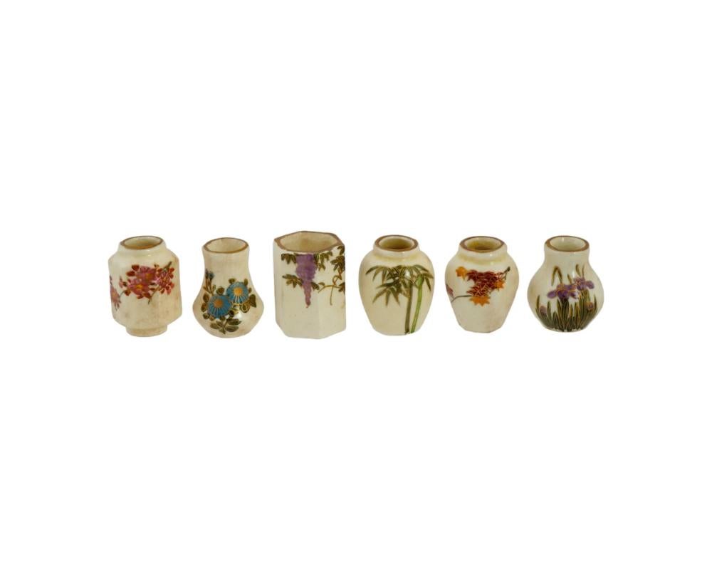A set of antique Japanese Satsuma porcelain vases. Late Meiji or Showa era, first half of the 20th century. A total of 6 items of various shape. Miniature size. White bodies with individual hand-painted floral decor. Gilt accents and rims. The set