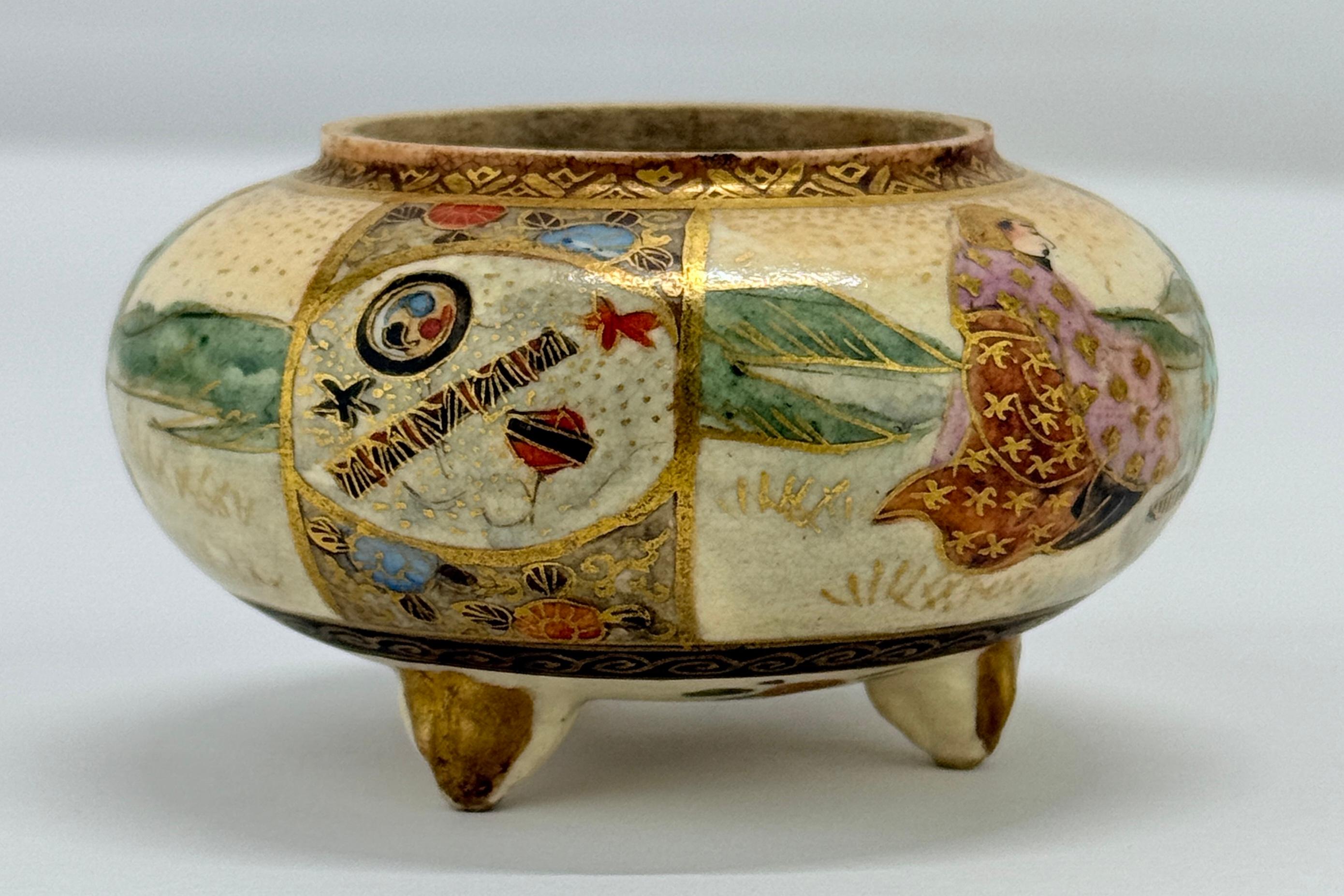 Este incensario de porcelana Satsuma en miniatura, de la época Meiji, es un raro y exquisito ejemplo del arte de la cerámica japonesa. Apoyado sobre tres elegantes pies, el incensario está meticulosamente adornado con intrincados elementos