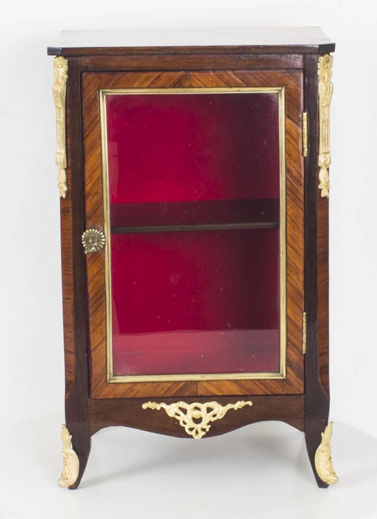 This stunning antique kingwood bijouterie table top cabinet dates from the mid-19th century.

It is a true rarity and has been accomplished in kingwood with decorative gilded ormolu mounts. It has a central shelf and is lined with a sumptuous red