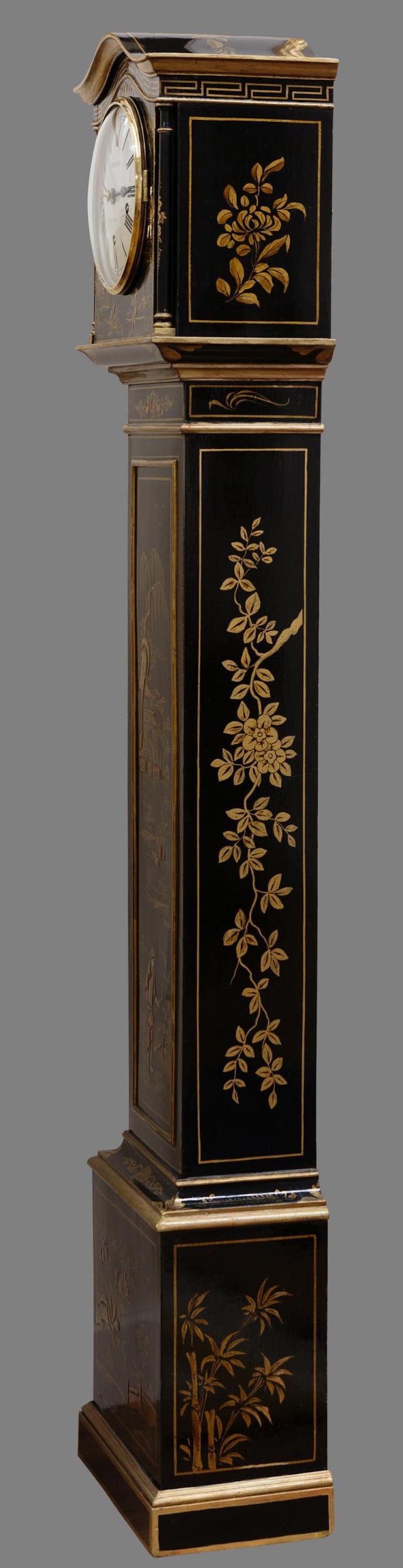 Miniature Longcase clock

Miniature Longcase clock standing on a stepped base and surmounted by a moulded shaped arch with fine raised Chinoiserie decoration on an ebonised ground. The case featuring typical Chinese country scenes with forests,