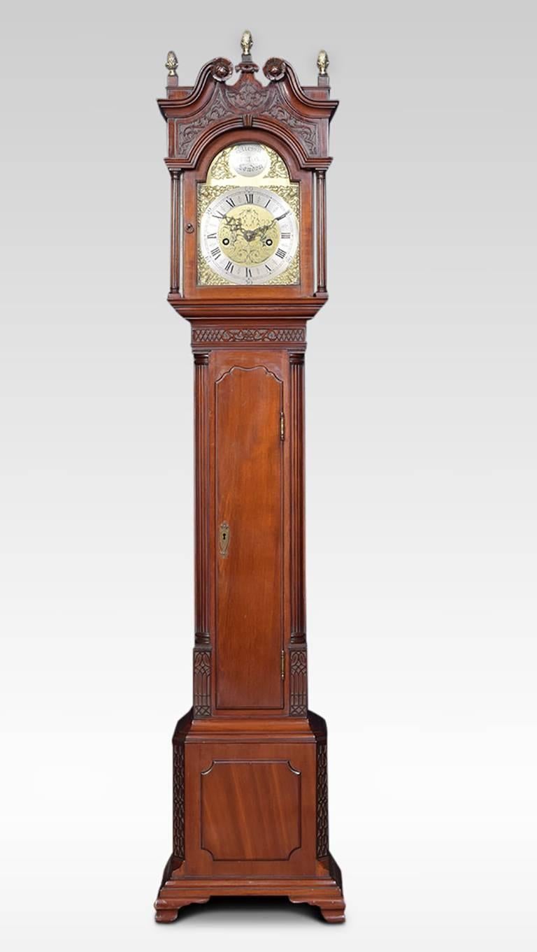 Mahogany cased grandfather clock of small proportions, the arched hood crowned with three brass acorn finials to the swan neck having wooden rosettes, the arched brass dial engraved with gilt-metal Roman numerals and decorated foliate face, the dial