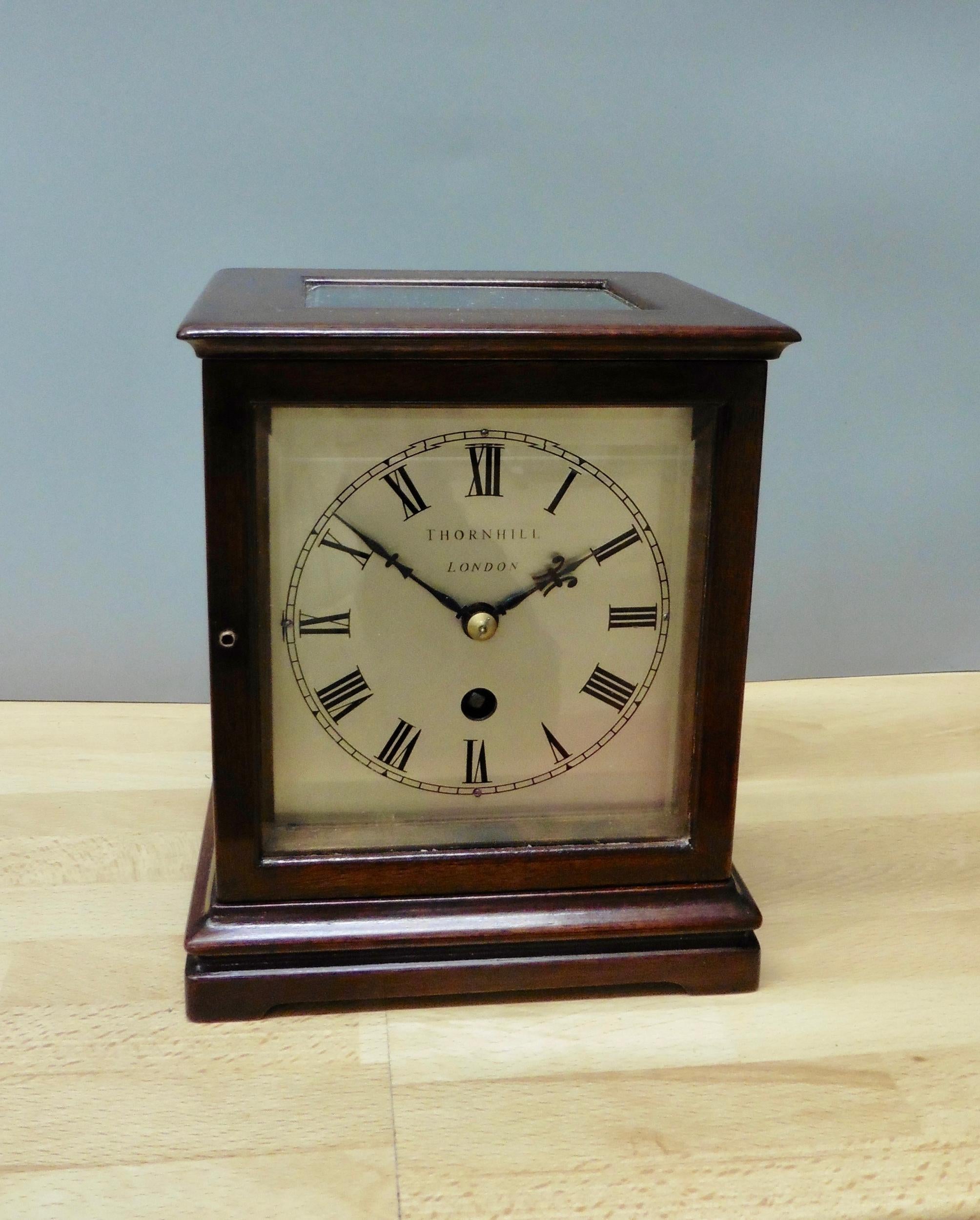 Miniature mahogany library clock, Thornhill, London

Miniature mahogany library clock standing on a stepped plinth with pad feet. Four glass panels with beveled glass and glass panel to the top to view the movement.

Silvered dial with Roman