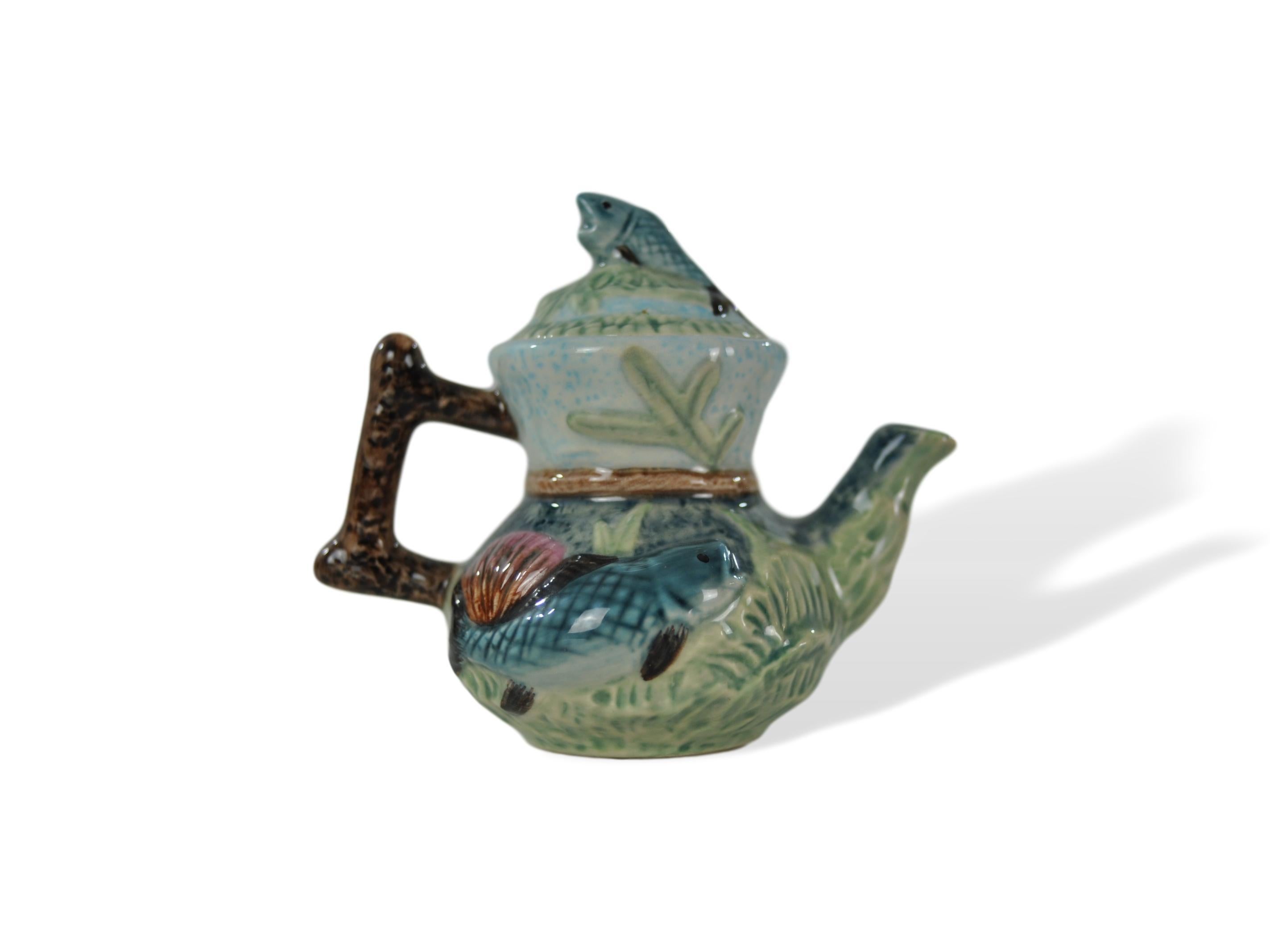 Miniature Majolica-glazed teapot, on a porcelain body, English, fish in waves pattern after shorter and sons, English, circa 1920. Mounted with a tiny sardine finial, this charming little piece is of extremely high quality; it is molded and glazed