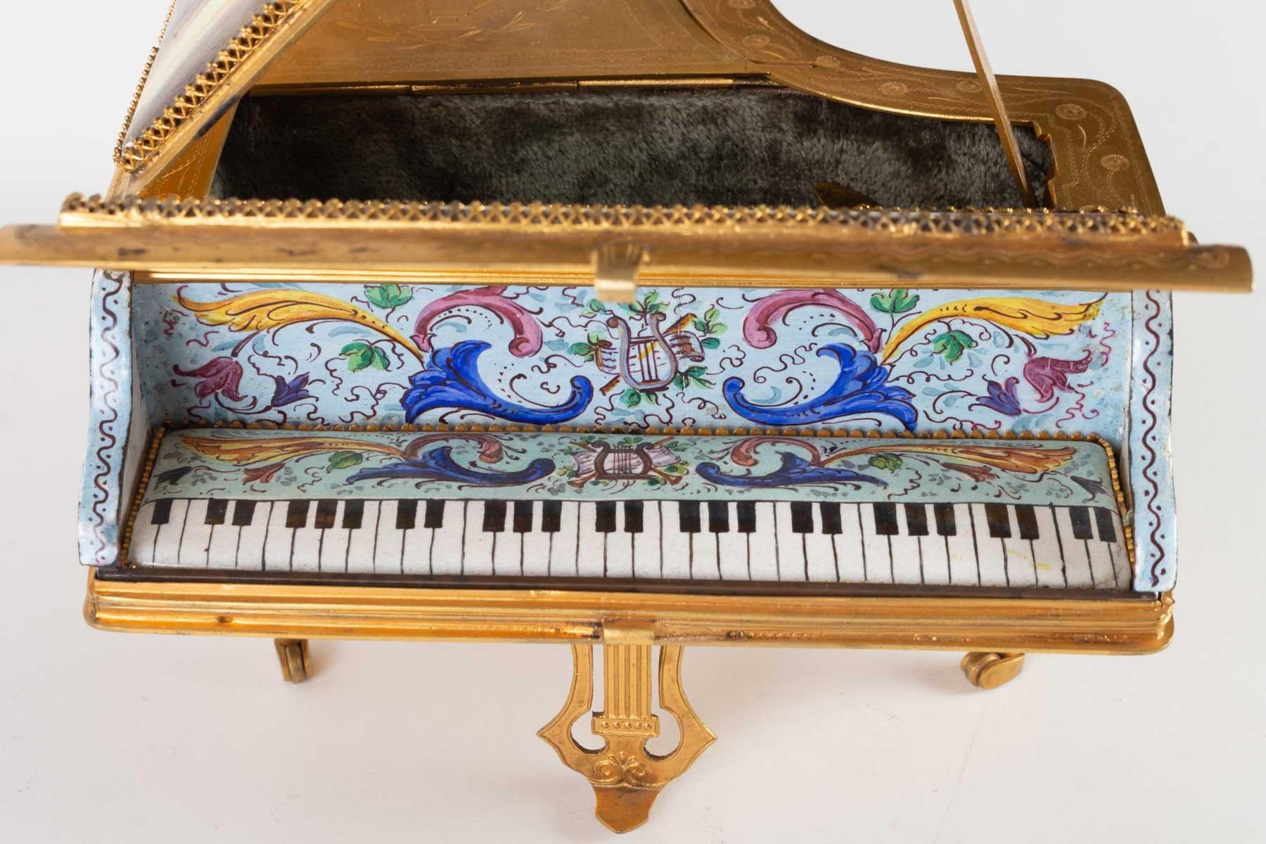 Miniature piano, music box in gilded brass and decoration of gallant scenes in enamel, 19th century, Napoleone III period.

Measures: H 9 cm, W 13 cm, D 17 cm.