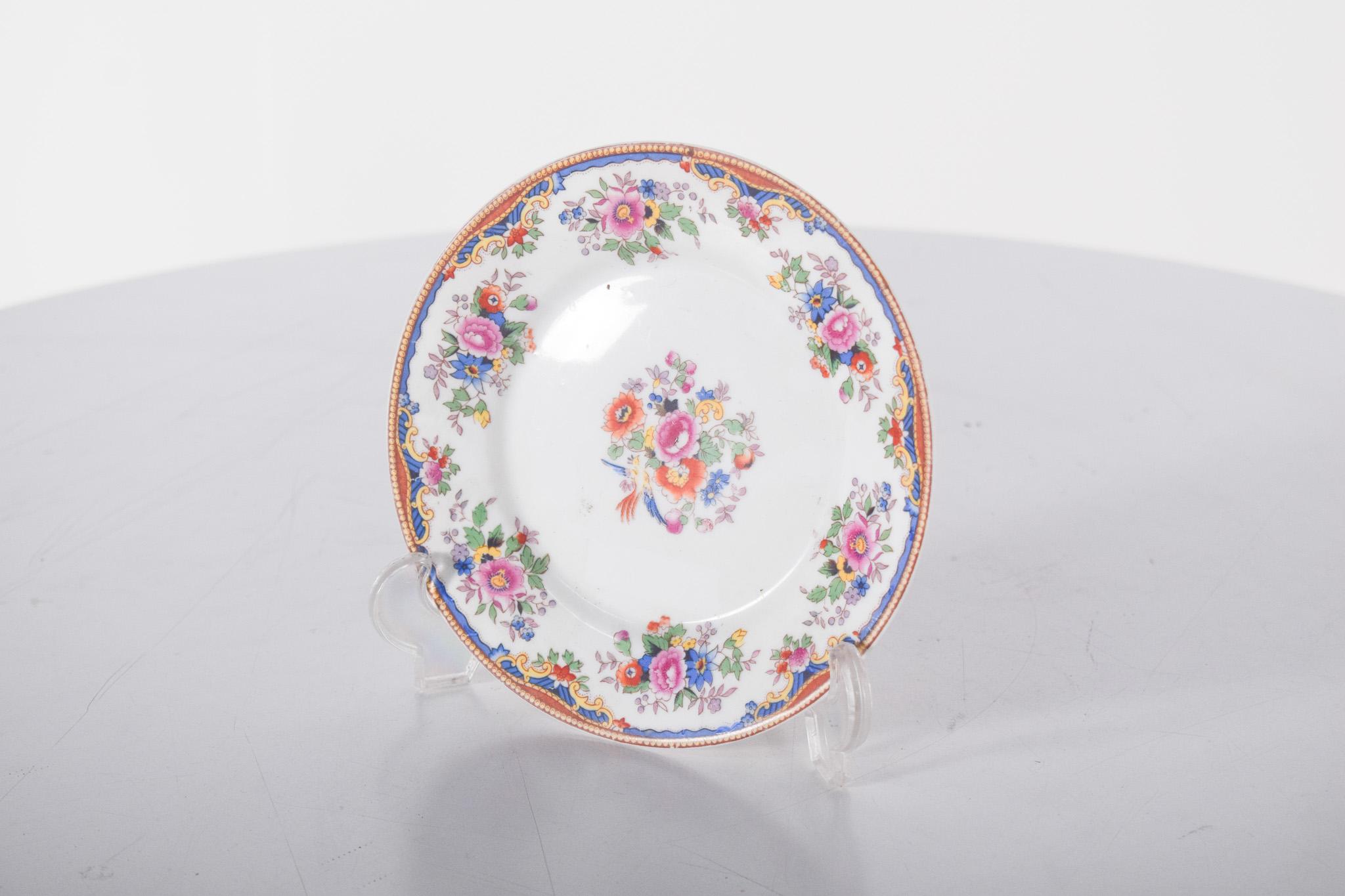 Plato miniatura, en porcelana de Electro Cerâmica de Vila Nova de Gaia. Decoración policromada con delicadas flores, caracterizada por un bello arreglo floral central y un borde ricamente adornado. El centro del plato muestra un armonioso ramo de