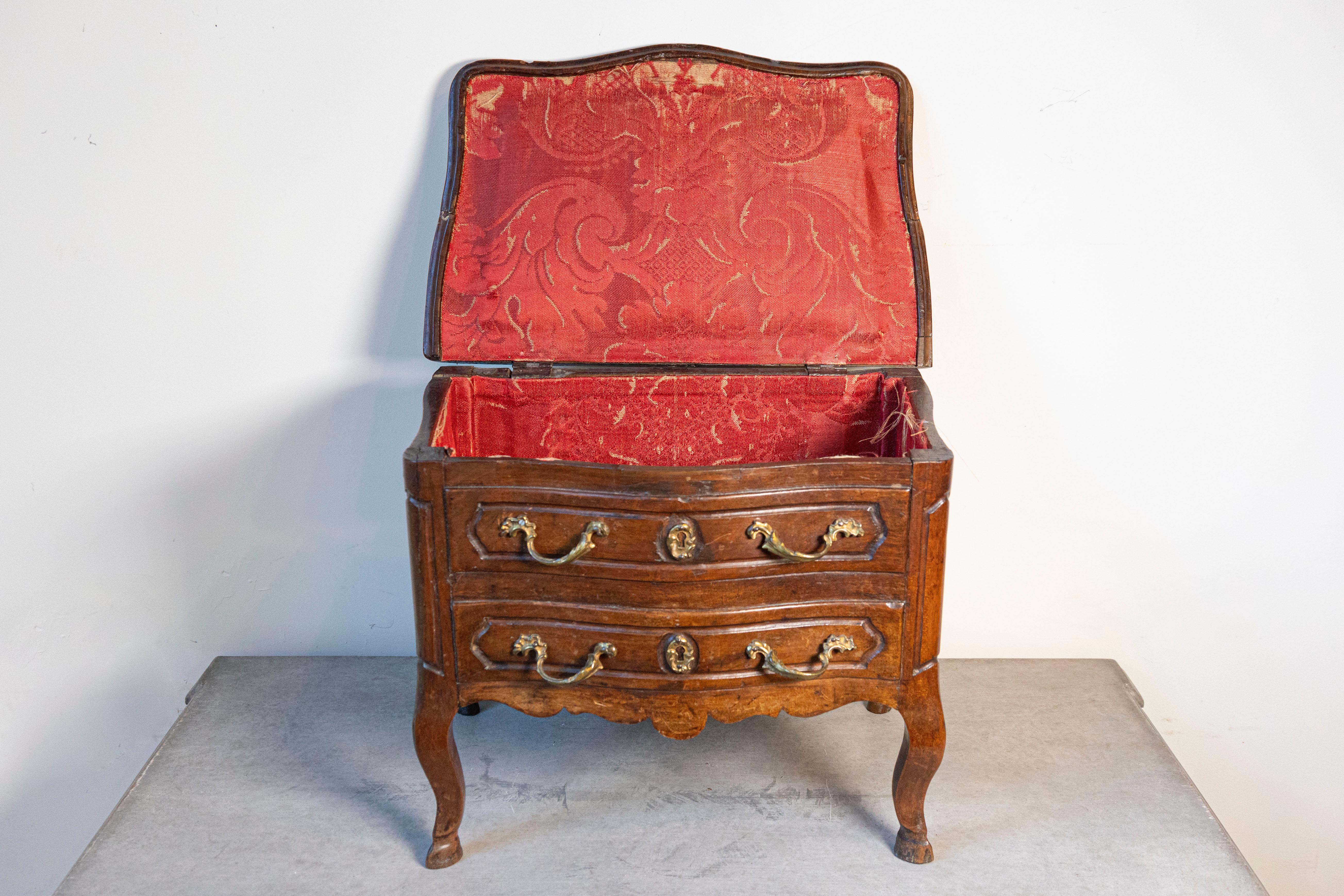 A French Provençale Louis XV period miniature apprentice commode from the early 18th century, with lift top and cabriole legs. Born in Provence during the reign of King Louis XV, this miniature chest was created to demonstrate an apprentice