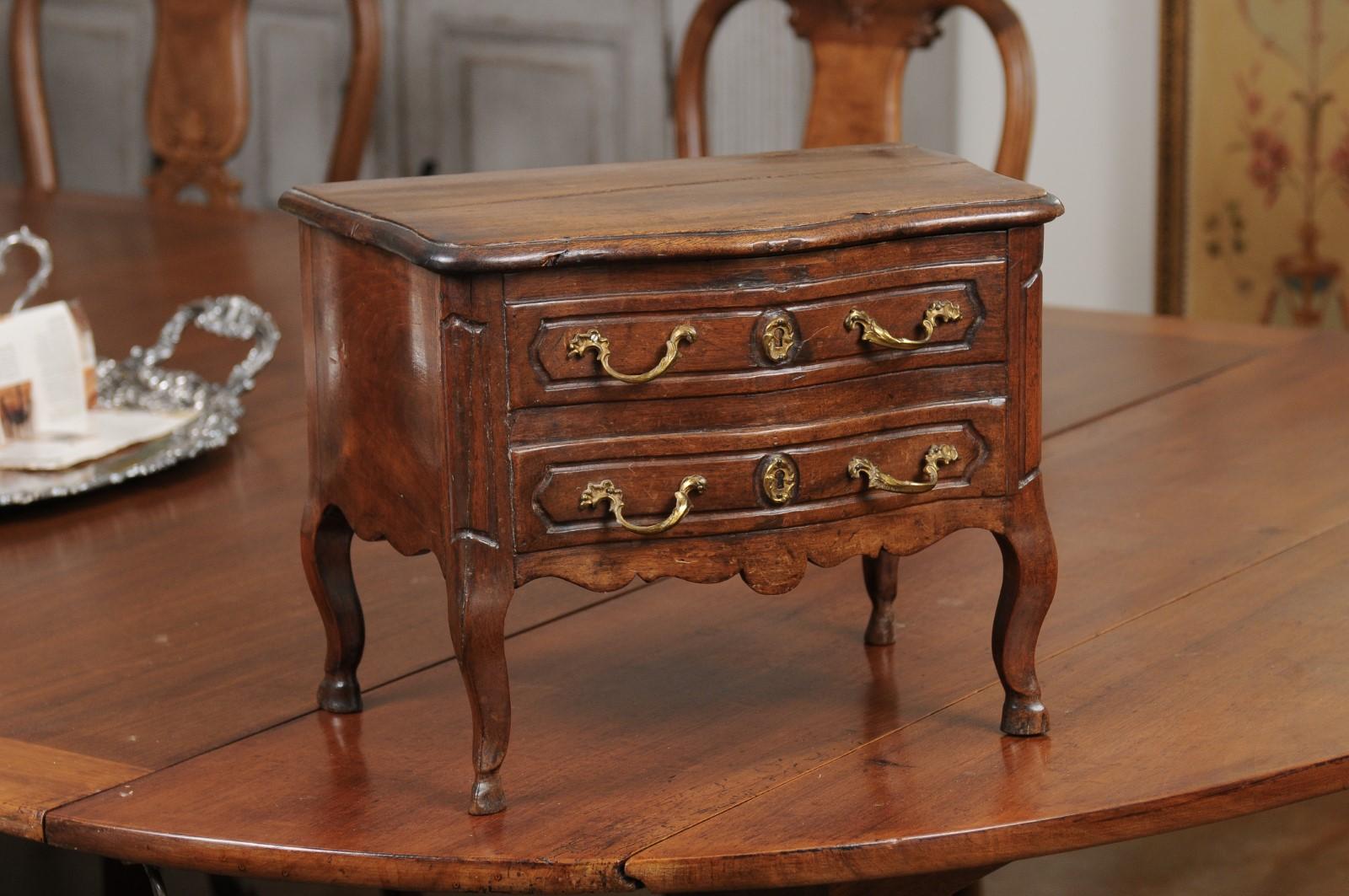 Commode d'apprenti d'époque Louis XV, de style provençal français, du début du XVIIIe siècle, avec plateau à élévation et pieds cabriole. Né en Provence sous le règne du roi Louis XV, ce coffre miniature a été créé pour démontrer le savoir-faire