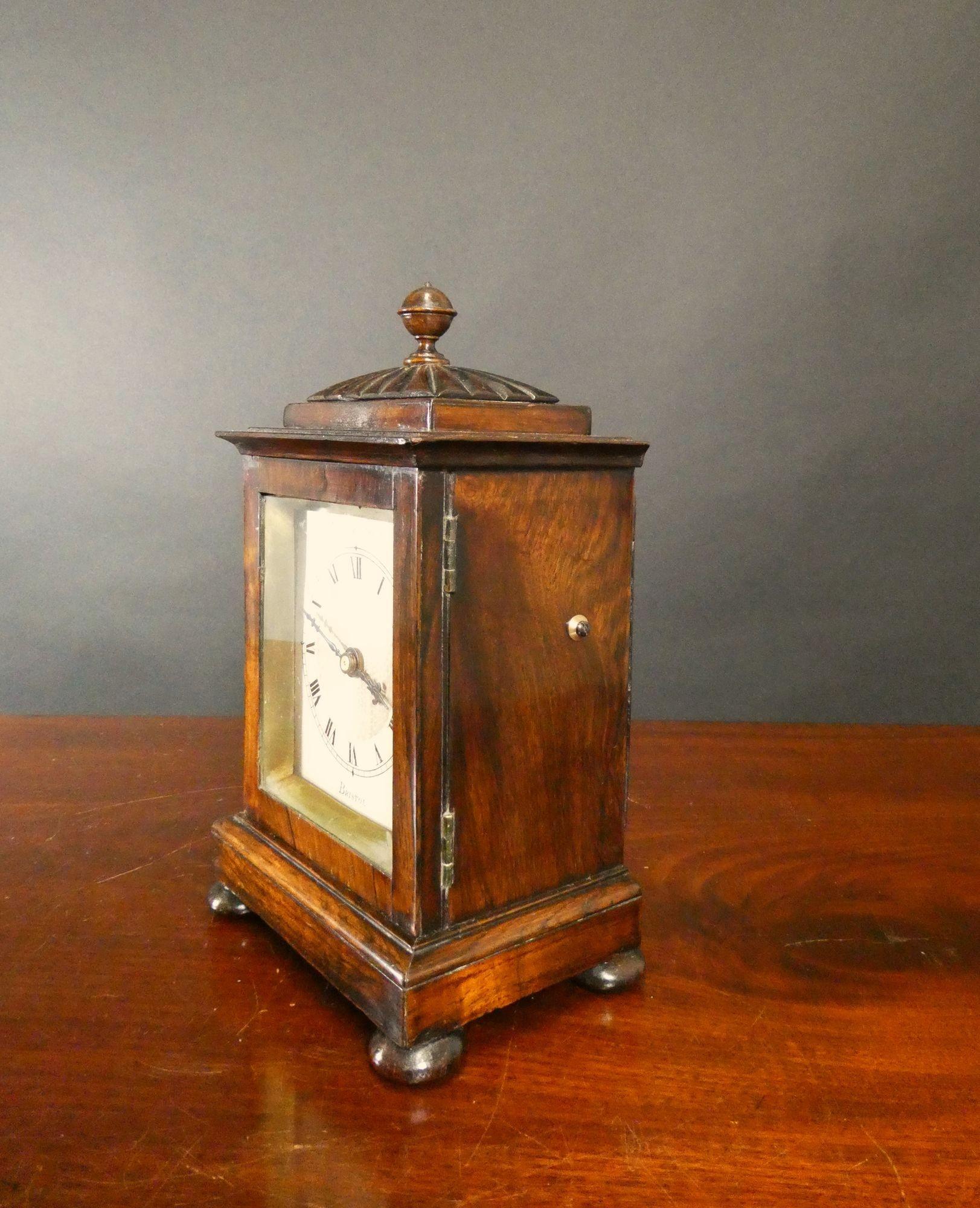 Miniature ‘Bracket’ style mantel clock in a finely figured Rosewood case with a gadroon top standing on bun feet and mounted with a spherical finial.

Fine engine turning to the silvered dial with Roman numerals, original ‘blued’ steel hands signed