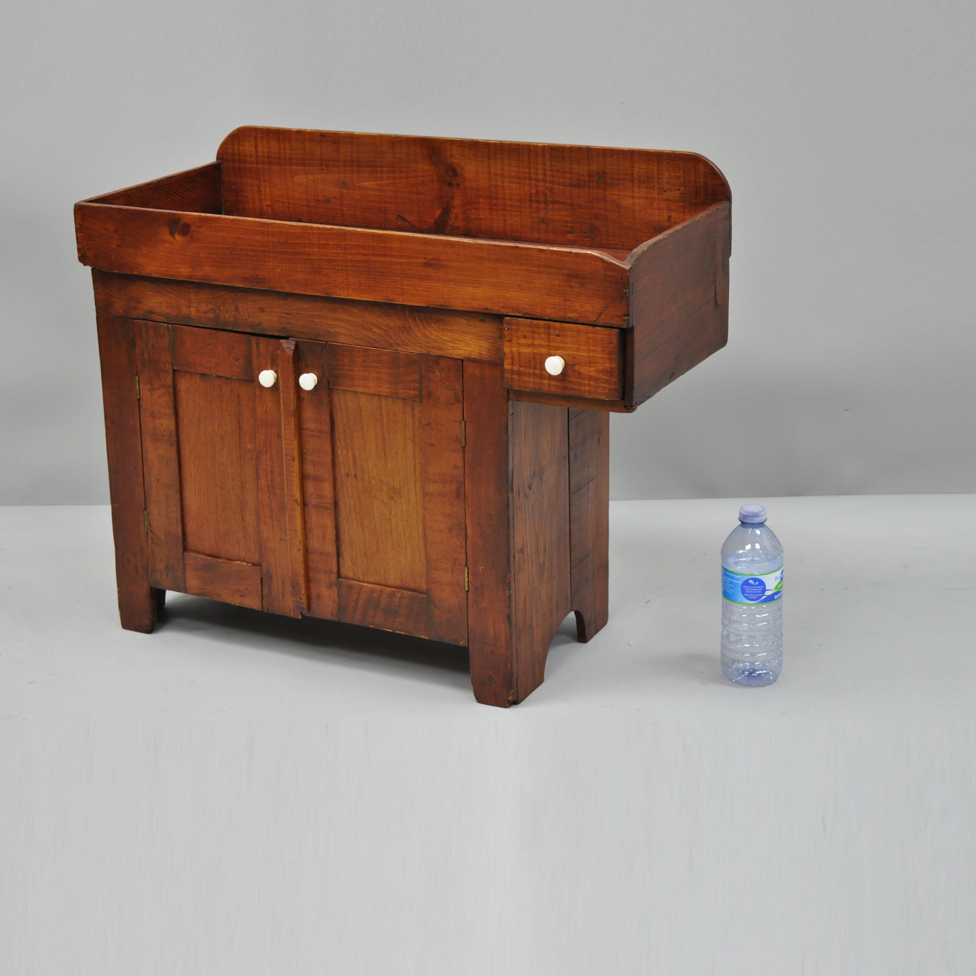 Miniature salesman sample 19th century American dry sink cabinet. Item features solid wood construction, beautiful wood grain, 2 swing doors, 1 drawer, very nice antique item, quality American craftsmanship, circa early 19th century. Measurements: