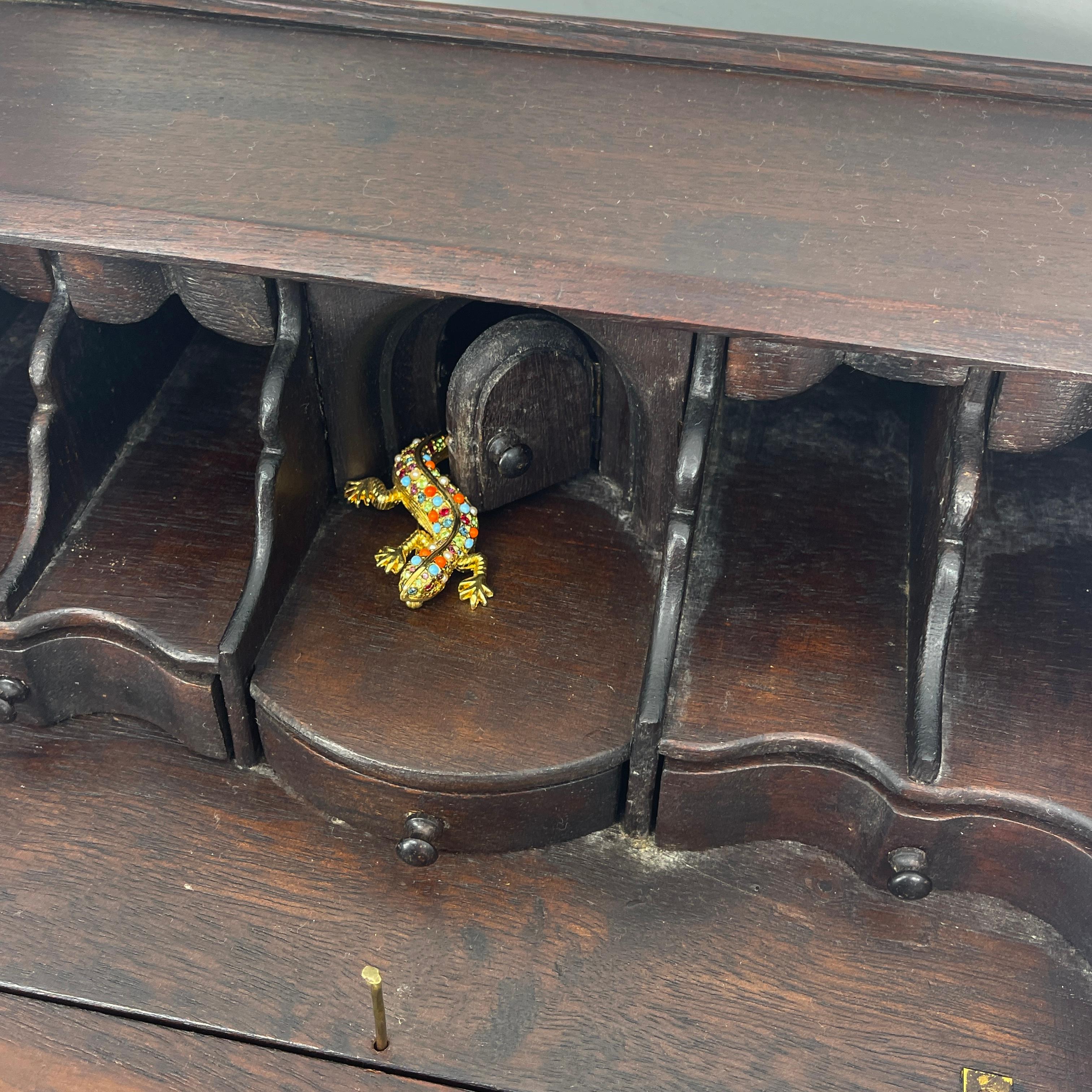 Danish 1920-40s Miniature oak slant-front secretary with multiple drawers.
The 3 drawers to the secretary are locked with a single centrally placed brass needle rod, please see detailed images enclosed.
   