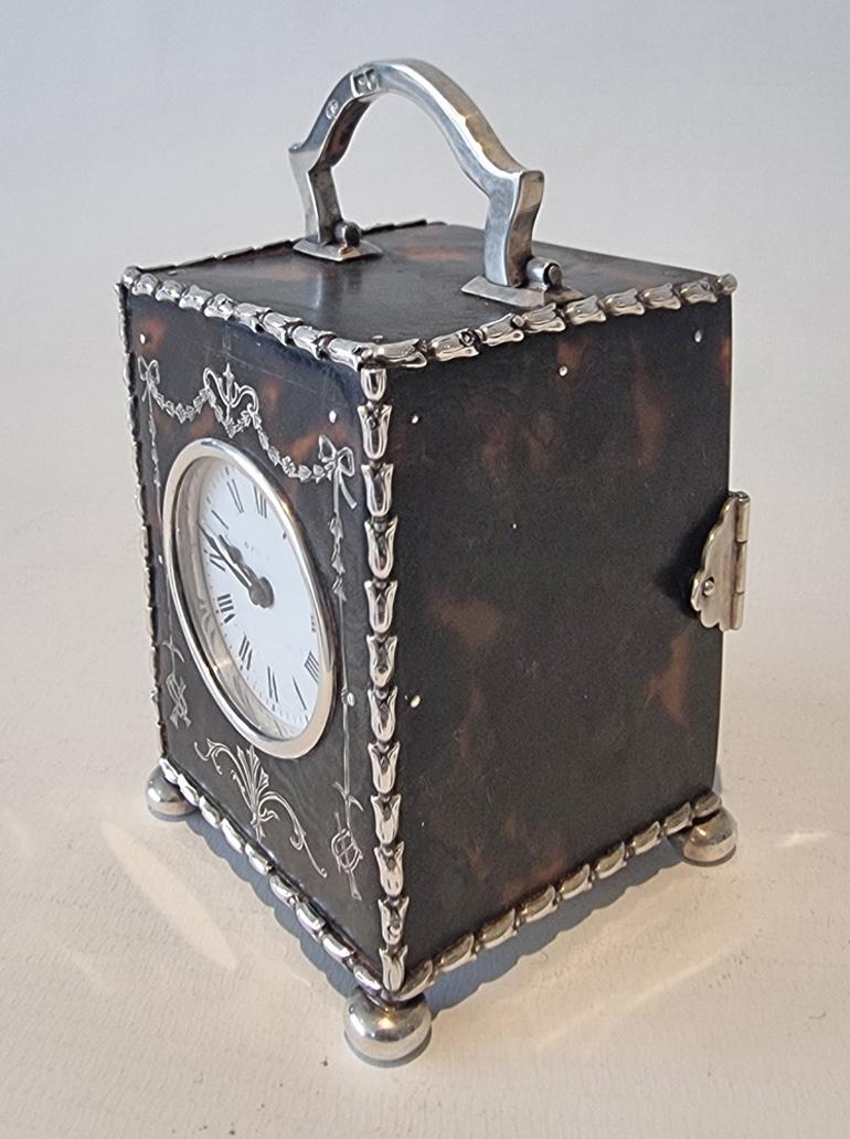 A very fine silver  piquet and tortoiseshell miniature carriage clock by William Comyns, in original leather case. Fine quality tortoiseshell carriage clock in perfect condition and from a private collection. Silver strapwork case with bun feet and