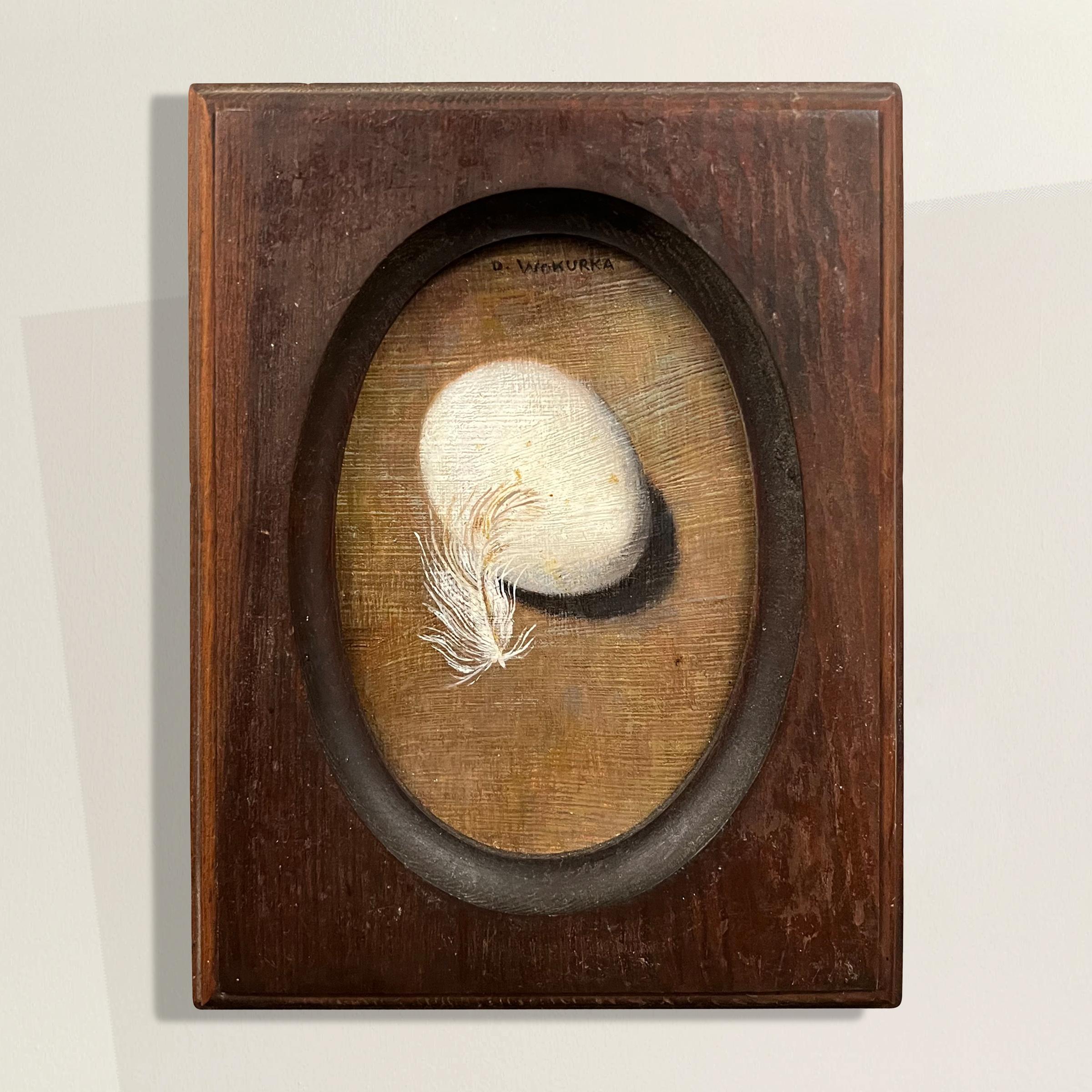 Painted by the celebrated Wisconsin artist Doris Wokurka (1929-1986), this exquisite miniature still life oil on board painting artwork captures a delicate composition of a chicken egg and feather. Measuring perfectly to fit an antique frame with an