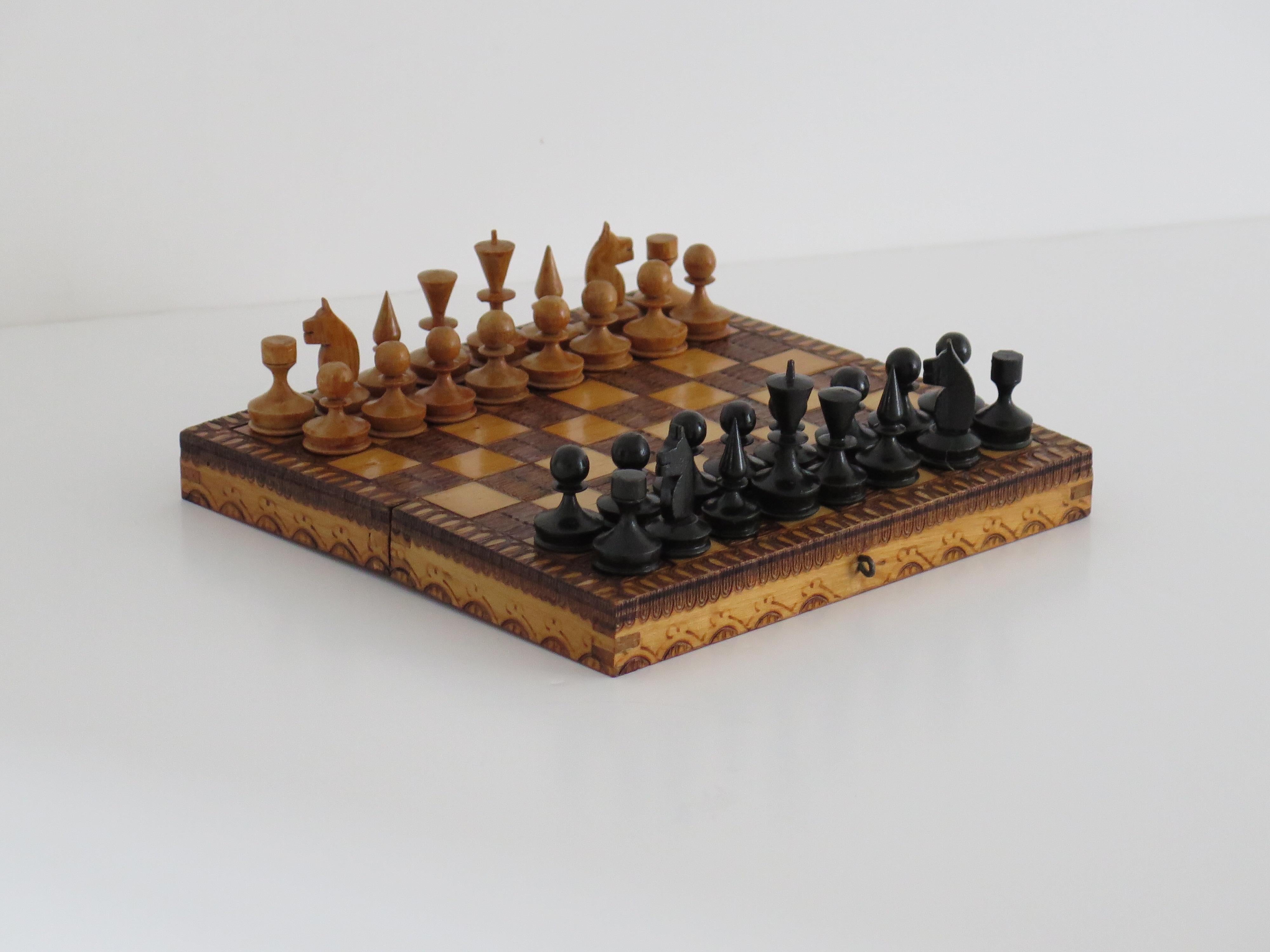 This is a good quality handmade Miniature or travelling wood chess set game of 32 pieces in its own lidded pokerwork decorated box, which we date to the English Edwardian period, circa 1910.

This piece is all handmade. The chess set is complete