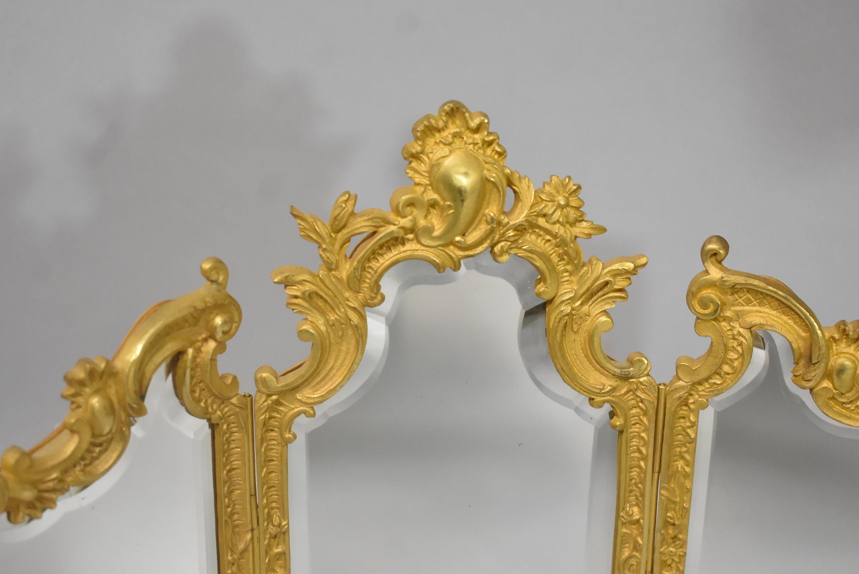 Miniature doré gold triptych beveled dresser or vanity mirror. Female figural face lower center.