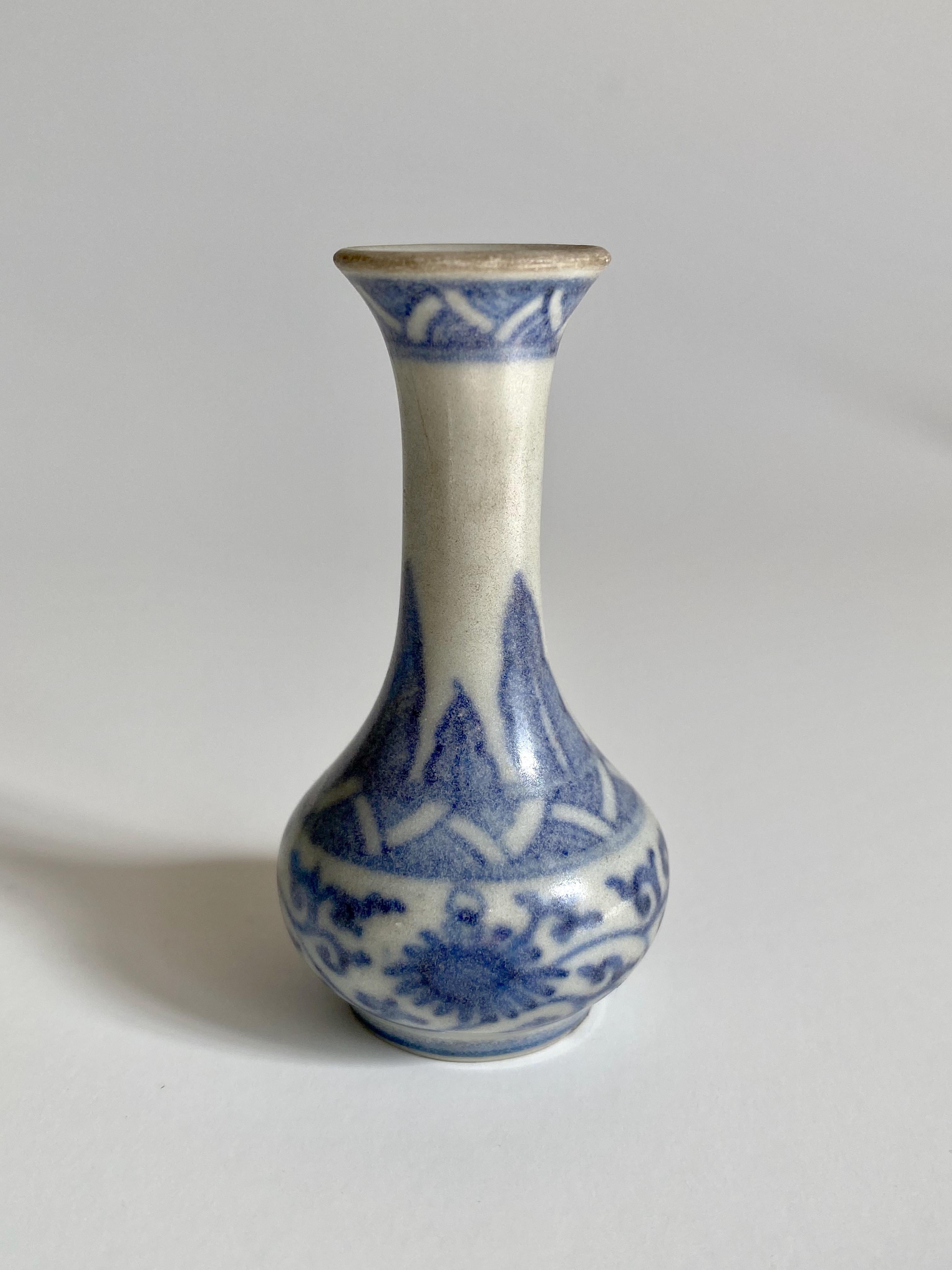 Miniature 17th century blue and white vase with a fluted rim and three bands of decoration 
 
This miniature vase was part of a hoard recovered by Captain Michael Hatcher from the wreck of a ship that sunk in the South China sea in approximately