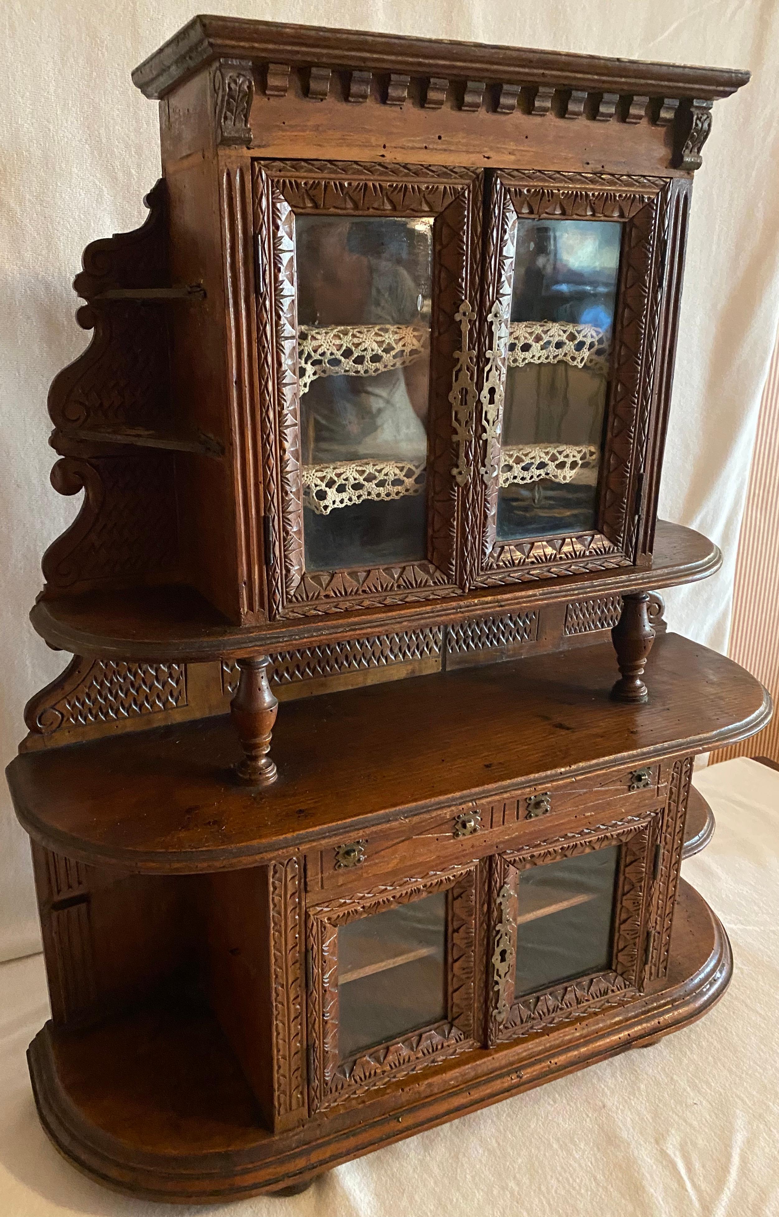 A wonderful miniature china cabinet, turn of the century, probably a
sales man's China Hutch sample. Lovely carved details, glass doors framed
with hand carved details. Some minor worming, and some age related
wood shrinkage of the back boards.
  