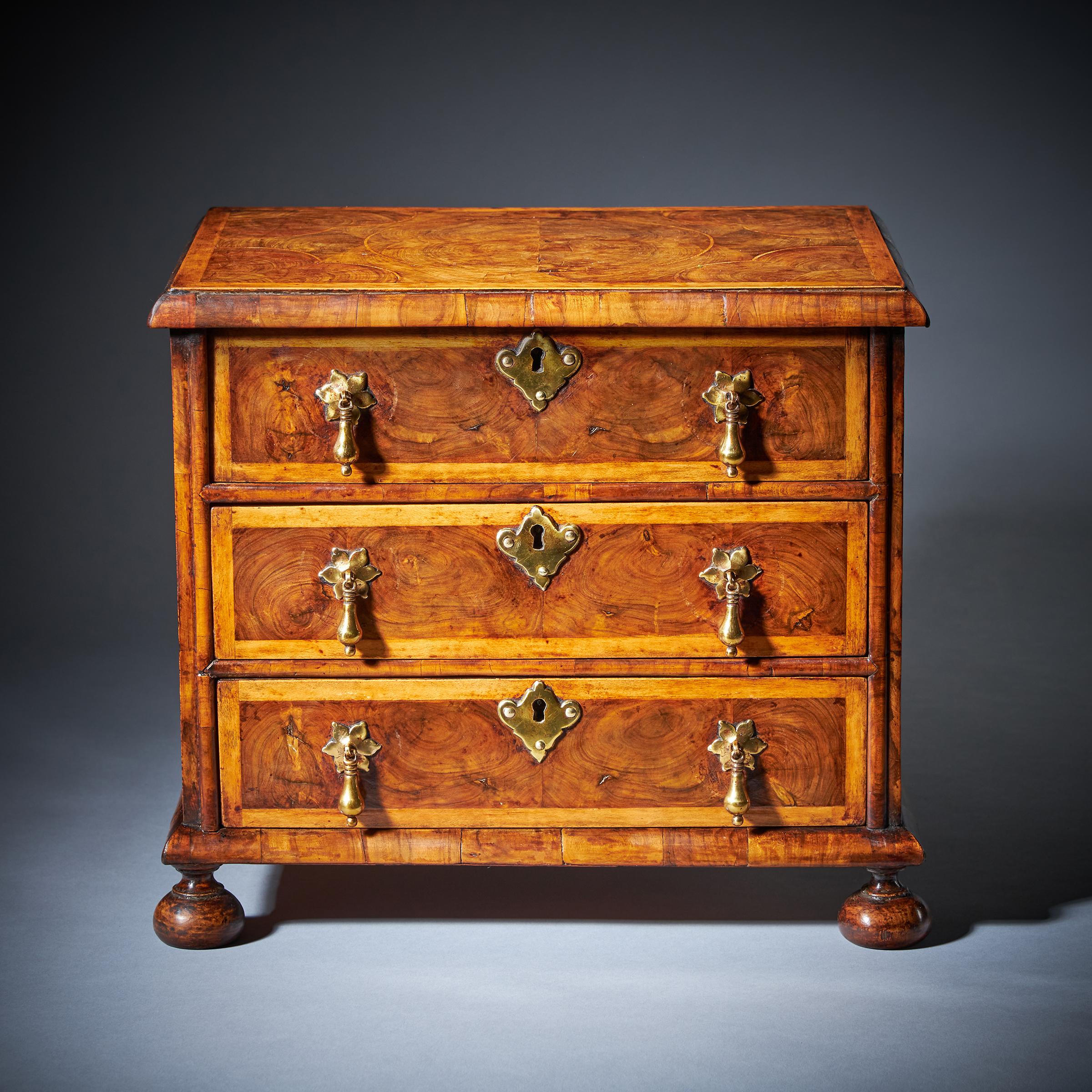 A Fine Miniature William and Mary 17th Century Diminutive Olive Oyster chest.
From the reign of King William & Queen Mary (1688-1702), England.

The finely holly-banded and cross-grain moulded top is beautifully veneered in roundels of hand-cut