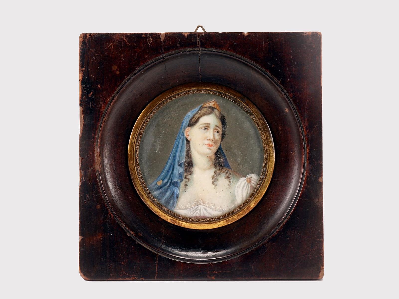 Miniature with female subject, watercolor on ivory.
The frame, in waxed fruit wood, is square in shape with a circle inside. The circle is bordered by a gilt brass decoration which fixes the glass.
The miniature represents a female figure with a
