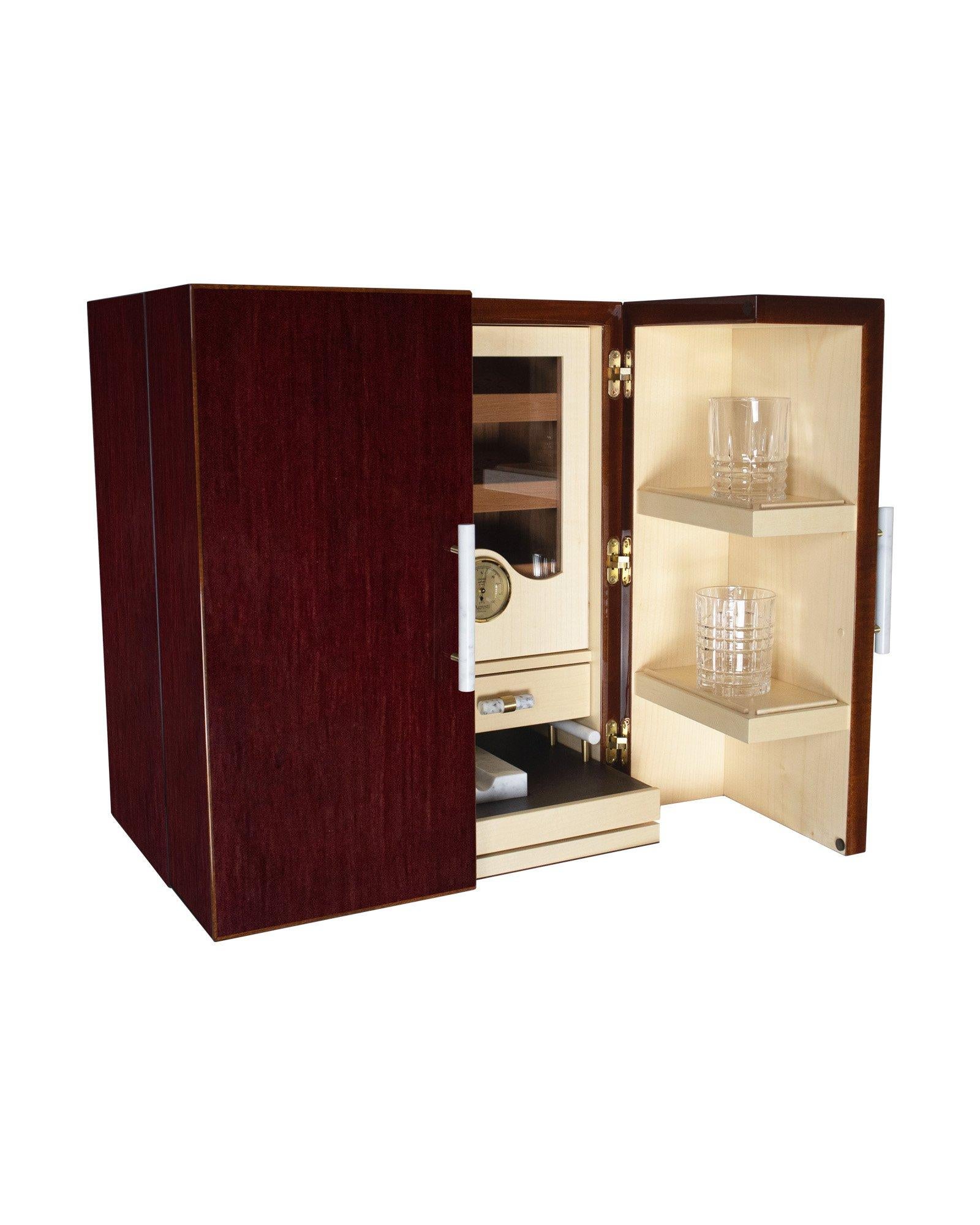 Coffre à minibar en chêne rouge et profils d'acajou, finition brillante. A l'intérieur se trouve un service à whisky en cristal. Humidificateur et hygromètre pour les cigares. Poignées en marbre blanc et laiton brossé. Plateau amovible avec cendrier