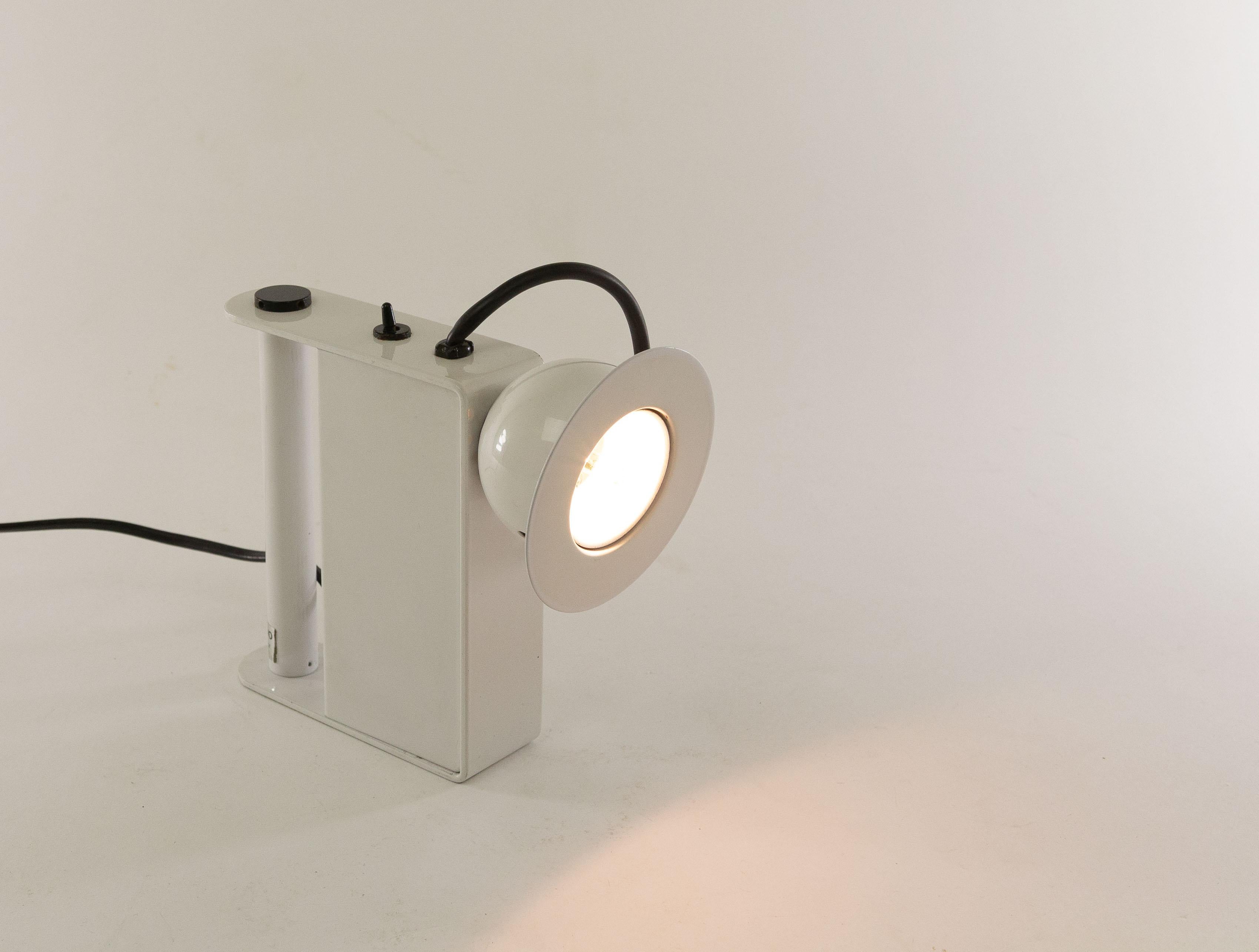 Minibox table lamp designed by Gae Aulenti & Piero Castiglioni and manufactured by Stilnovo in 1980.

This halogen table lamp can also be used as a 'torch' thanks to the handy handle. However, due to the power cord, it can only be used inside the