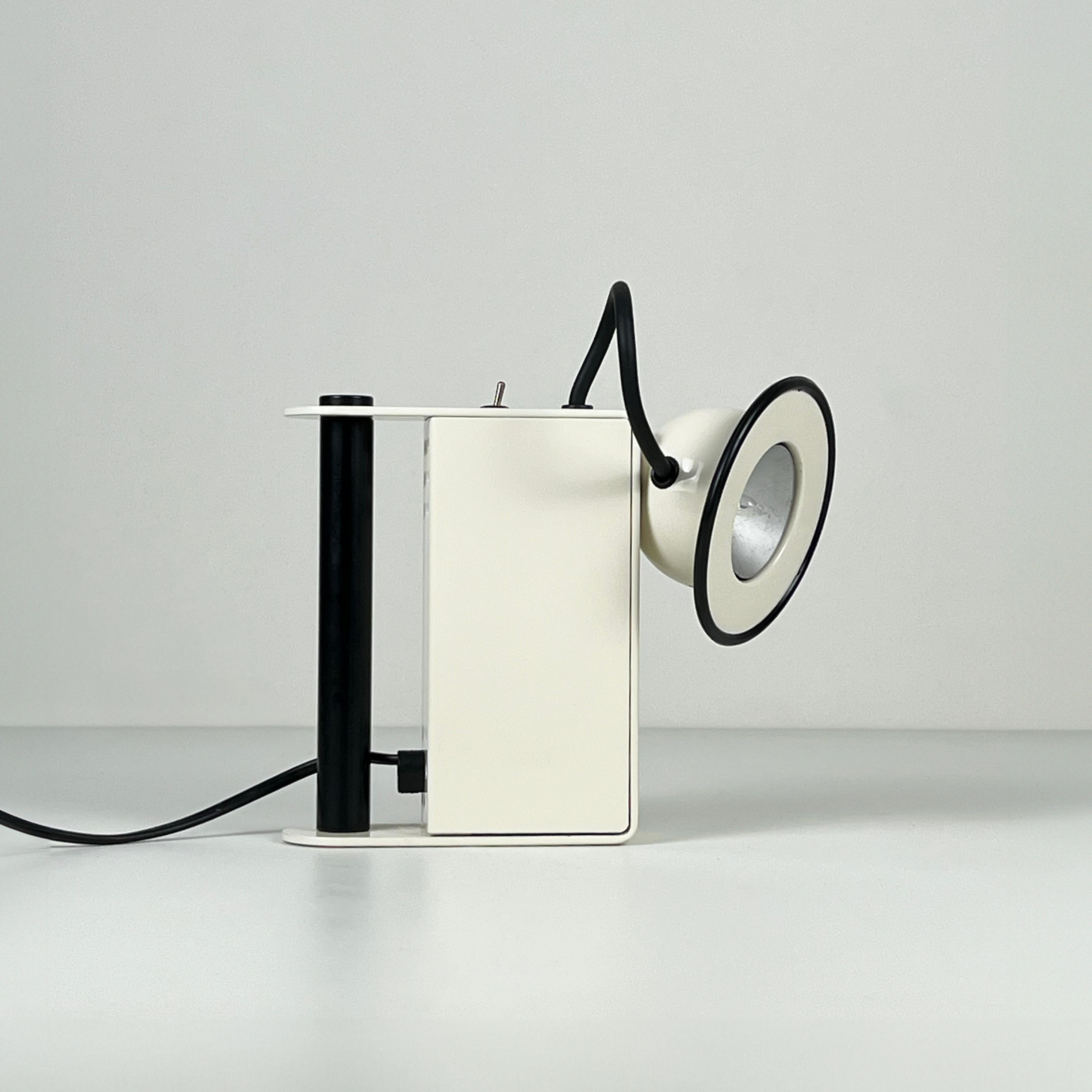 The 'Minibox' table lamp, conceived by Gae Aulenti and Piero Castiglioni in the 1980s, is a whimsical reinterpretation of a miner's 'torch.' Featuring a magnetic attachment, the reflector on the lamp's body offers users limitless options and optimal