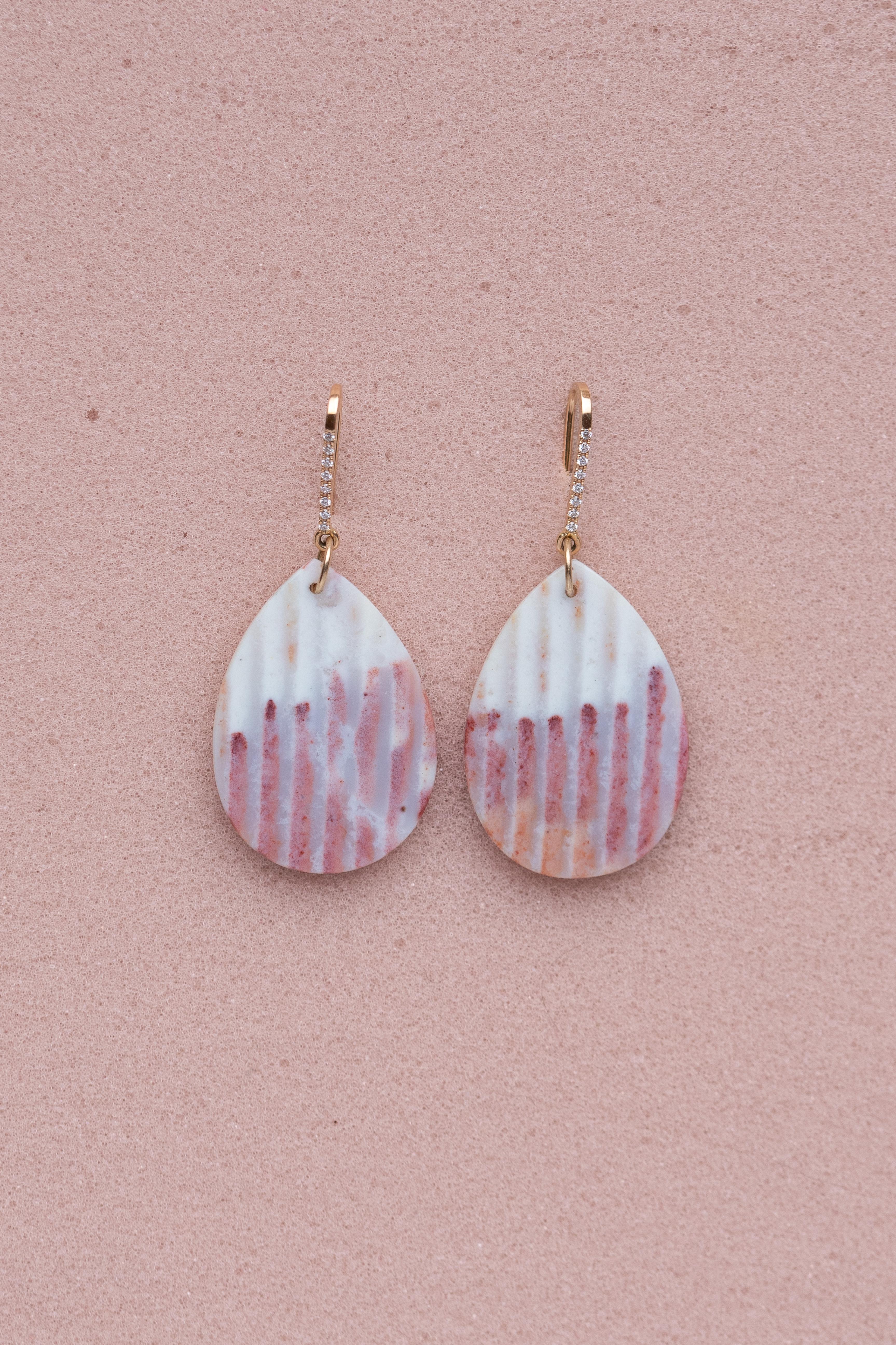 Gli orecchini MINIE sono caratterizzati da dischi di calcedonio a forma di goccia color rosa cipria, che emanano una bellezza morbida e serena che aggiunge un tocco di eleganza a qualsiasi look. I toni delicati e rosa pastello del calcedonio sono