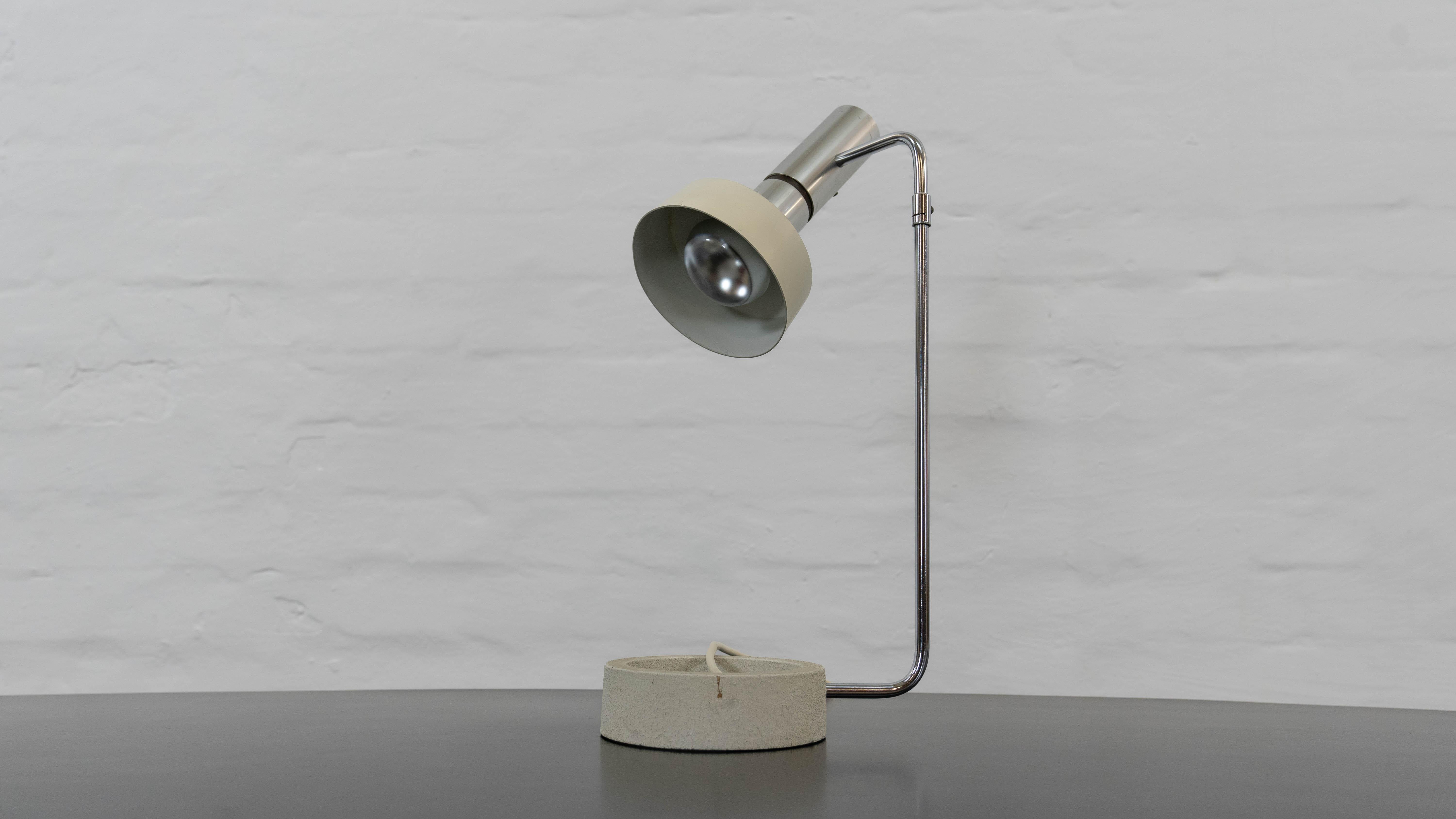 Adjustable Tablelamp , Model “Minilux”. Design and execution from the 1960s by Rico & Rosemarie Baltensweiler. E27 bulb socket, EU-plug. Lampfoot made from cast-iron. Lampshade is made of aluminium, mounted to a adjustable chromed bar. The