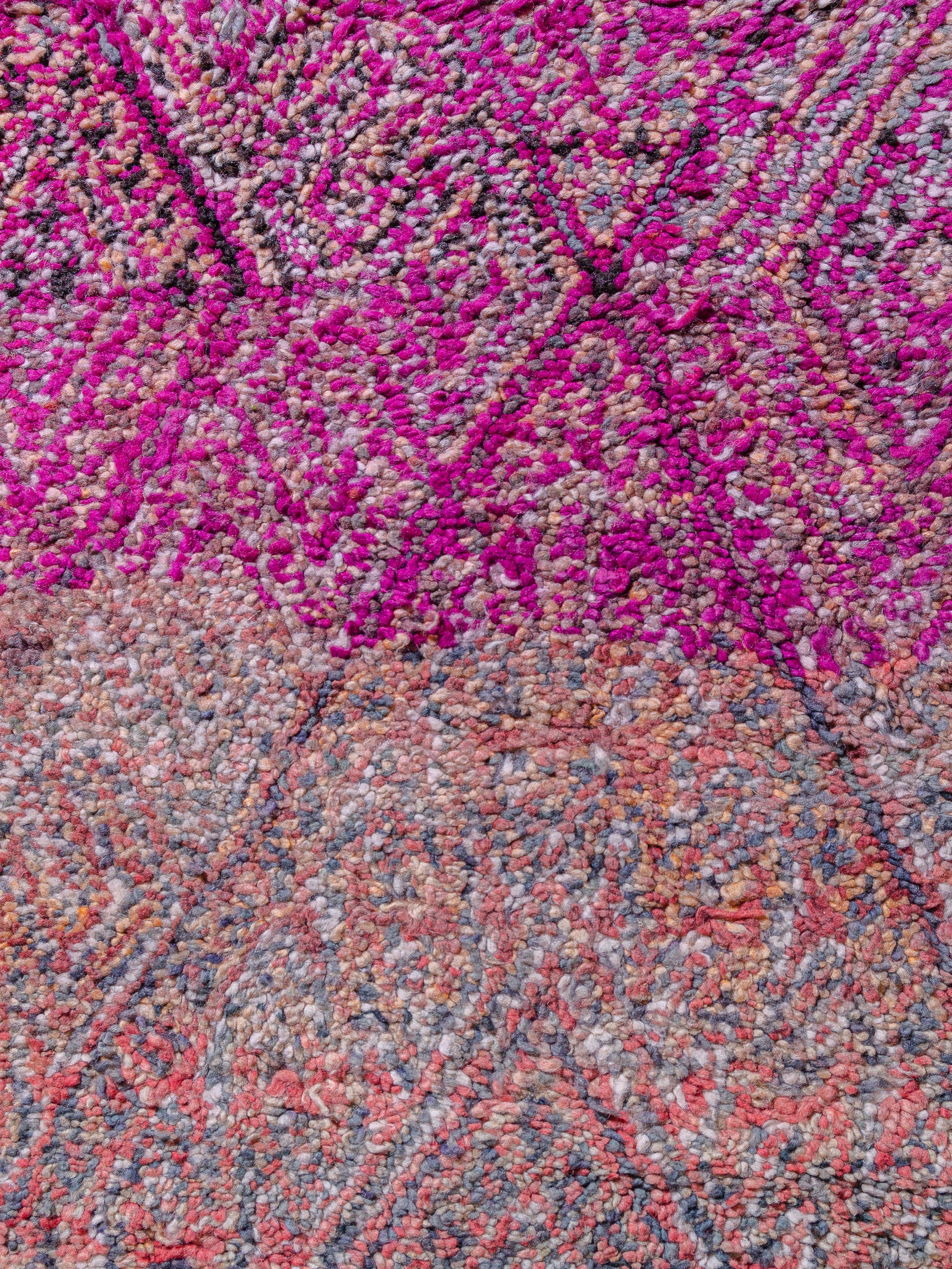 This vintage Beni M'Guild exhibits a uniform large-scale lozenge network knotted in faded salmon and coral. The rhythm is interrupted by a band of vibrant fuchsia, creating a striking contrast and increasing the volume of an otherwise quiet