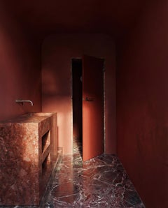 Bagno minimalista con doppio lavabo in travertino rosso e nicchie per riporre gli oggetti