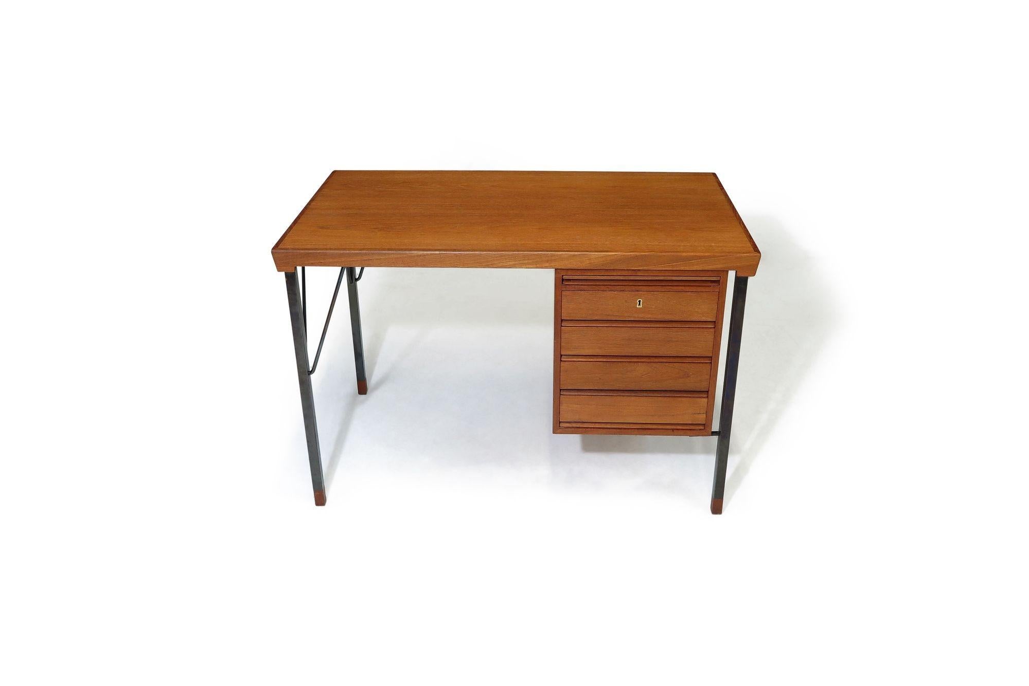 This Minimal Danish Teak Desk, designed by Peter Hvidt & Orla Molgaard-Nielsen for Soborg Moblefabrik, circa 1960 Denmark, is constructed with a four-drawer design including pull-out glass writing surface, locking top drawer, raised upon simple