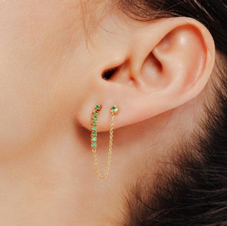 Minimalistische Smaragdketten-Ohrringe mit doppeltem Piercing aus 18 Karat Gold, um Ihren Look zu unterstreichen. Sie brauchen Ohrstecker, um mit Ihrem Look ein Statement zu setzen. Diese Ohrringe mit rundgeschliffenem Smaragd sorgen für einen