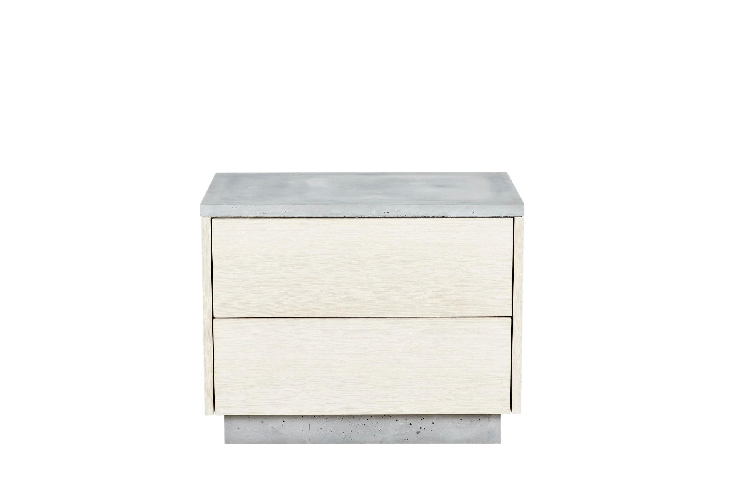 This 2 drawer end table features clean and simple lines. The exterior is composed of white stained rift-cut White Oak with an oil finish. The top and base are cast-concrete while the insides reveal a burst of mint-green color. The drawers are Blum