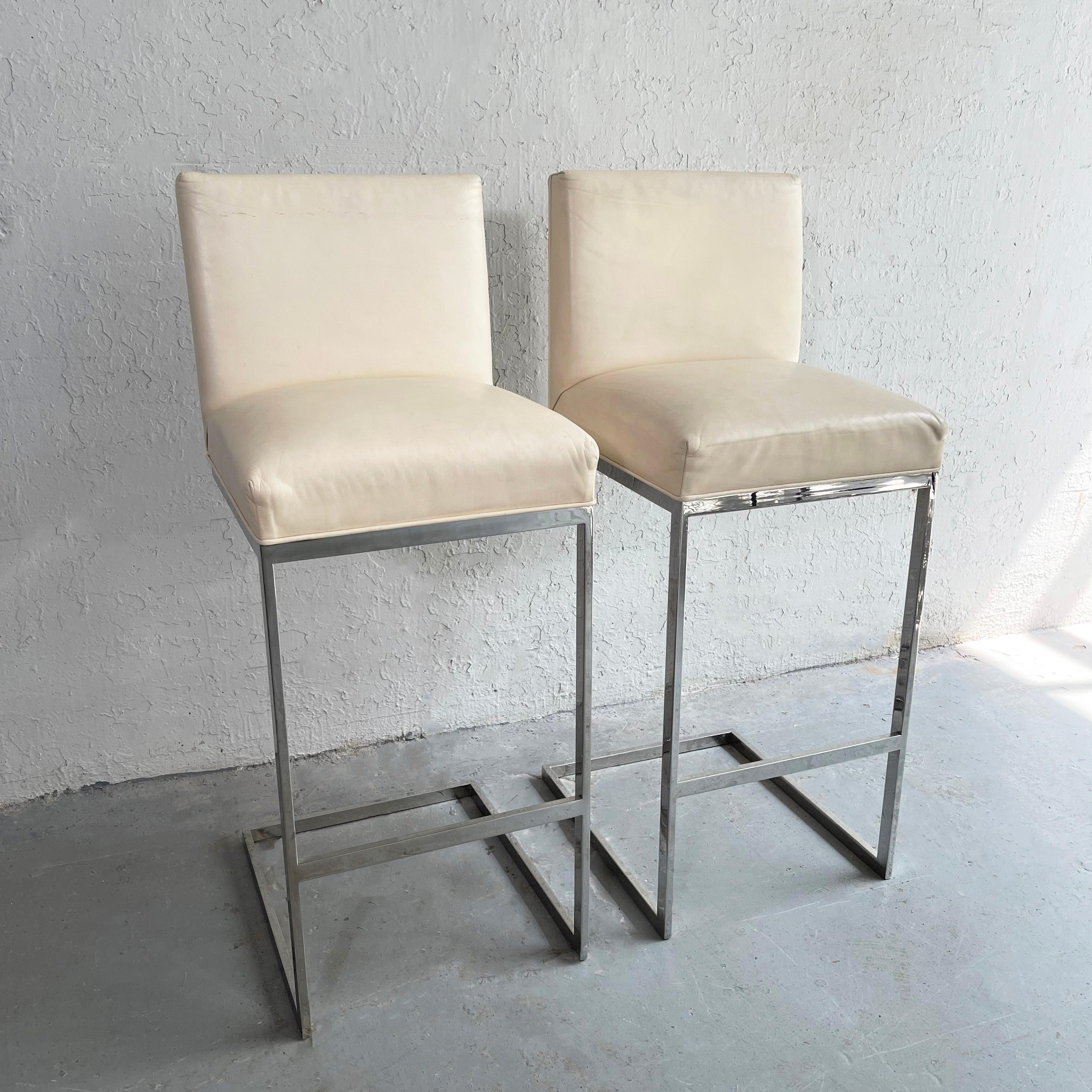Pair of sleek, minimal, post-modern bar stools feature flat bar chrome, cantilever bases with cream leather upholstery.