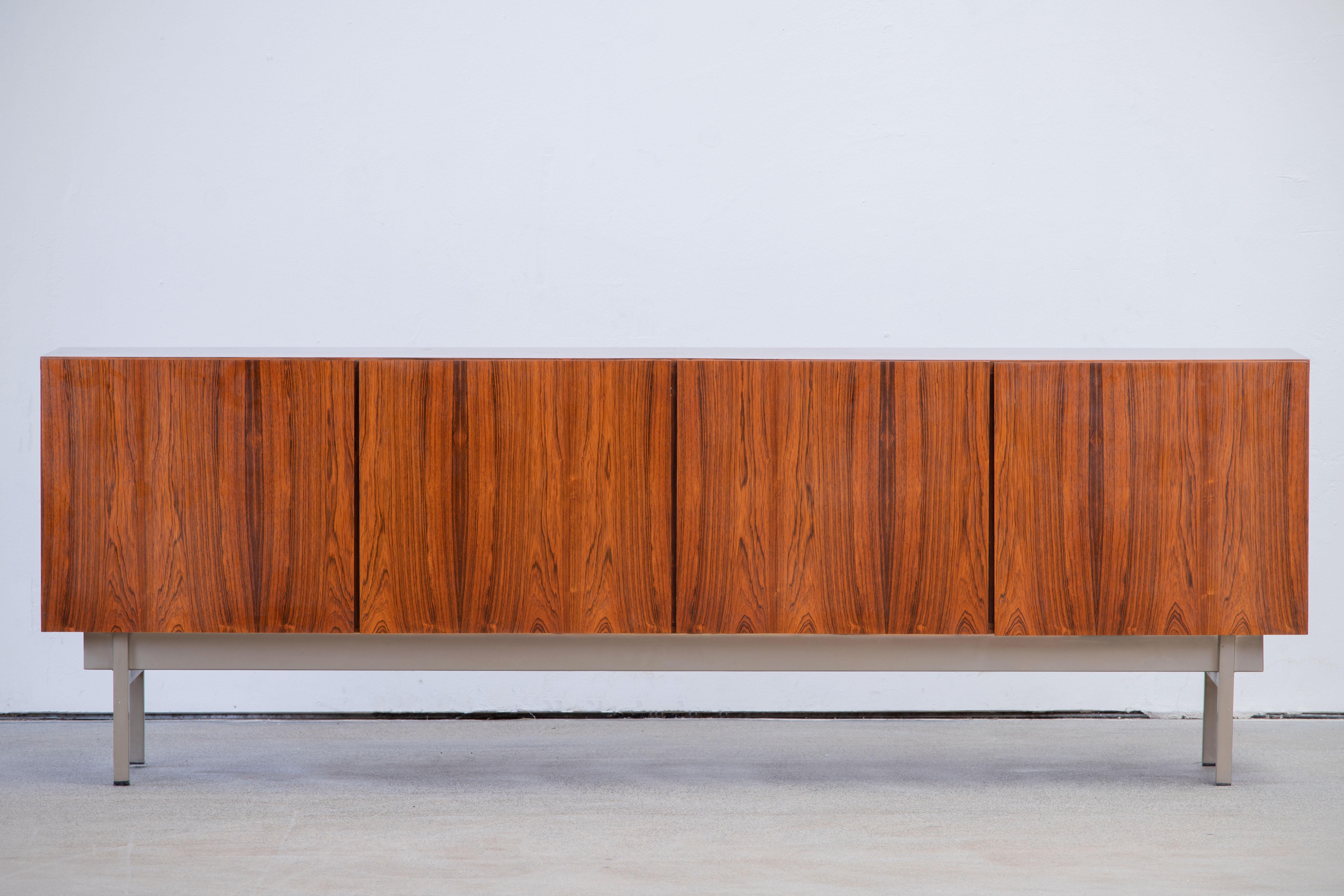 Stunning midcentury Cocobolo sideboard, 1960s, beautiful grain.
The row consists of three storage compartments with shelves and a drawers column. The sycamore interior brings an elegant contrast to the sideboard.
An elegant piece.
Good condition