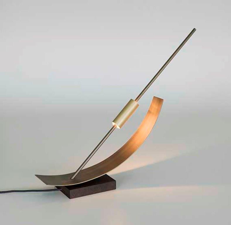 The proportions of this lamp are based on Le Corbusier's Modulor and was presented at the Milan Design Week in 2018.

It is composed of a wooden base, a slab and two overlapping brass tubes, containing a row of warm light LEDs: a modern, light and
